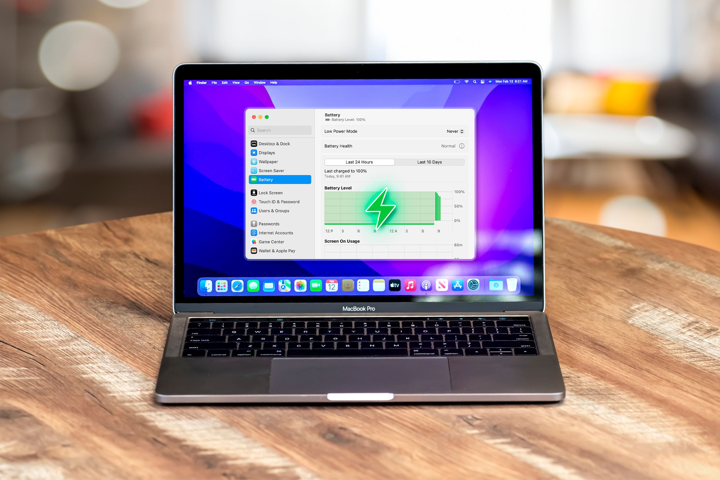 A MacBook Pro seen from the front above of a wooden desk with the battery settings screen displayed.