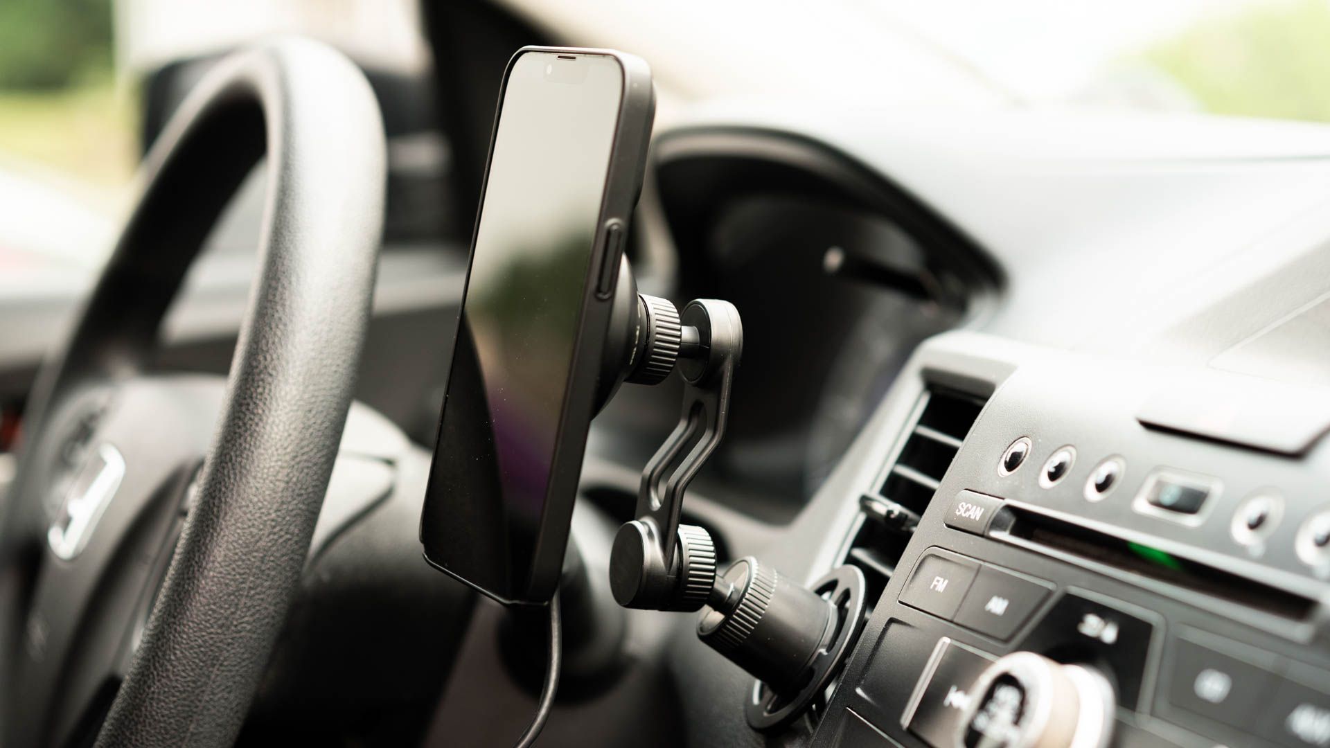 An iPhone mounted to the mophie Wireless Charging Vent Mount with MagSafe.