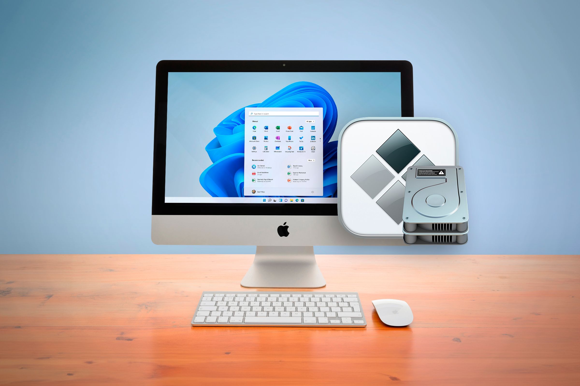 An iMac above a wooden table running Windows 11.