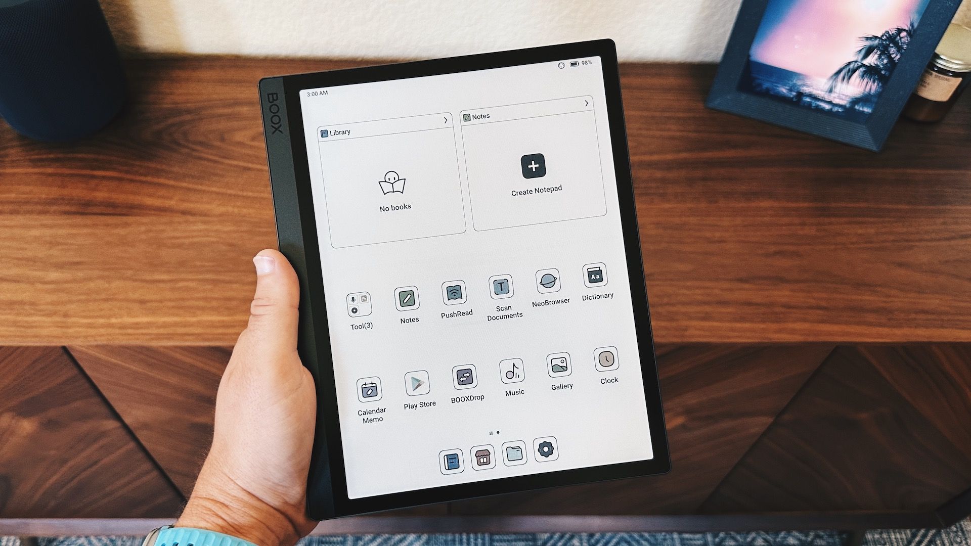 Boox Tab Ultra C being held in a hand showing its home screen icons.