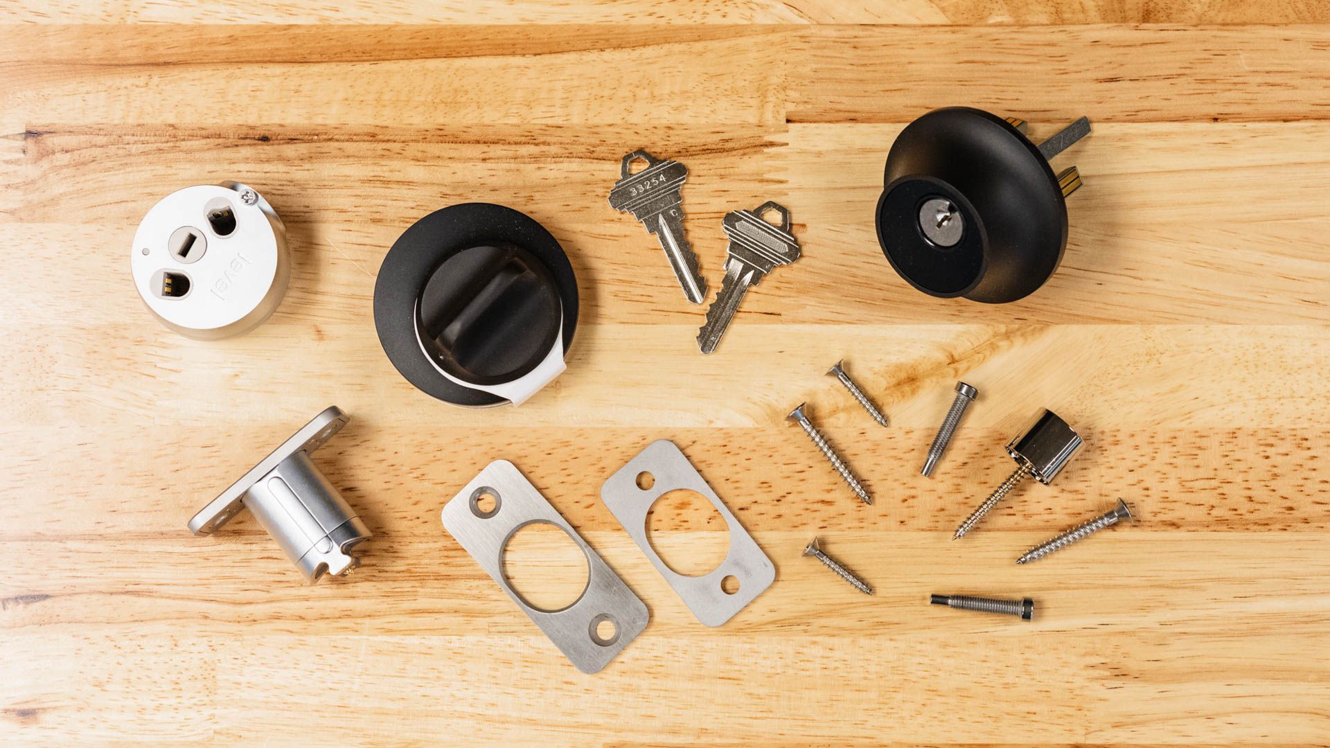 Components of a smart lock spread out on a workbench.