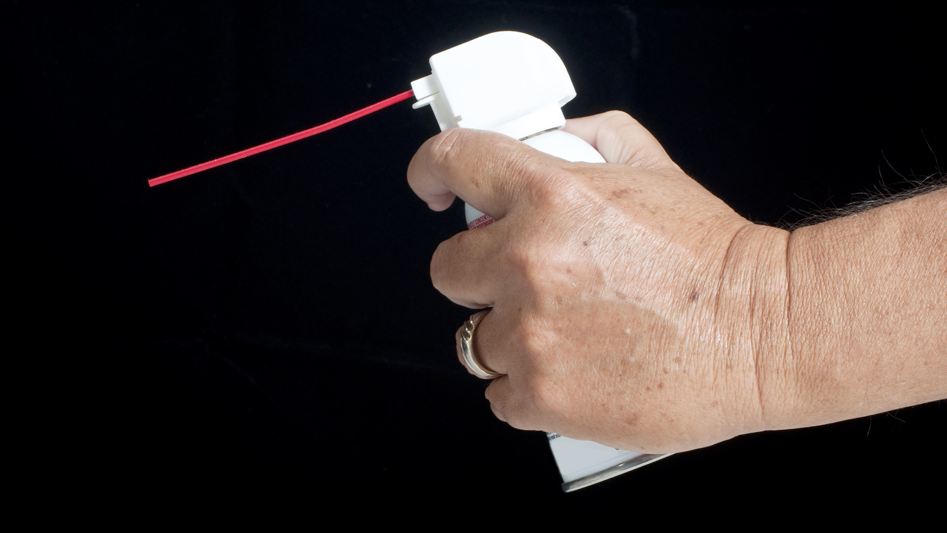 A hand holding can of air duster.