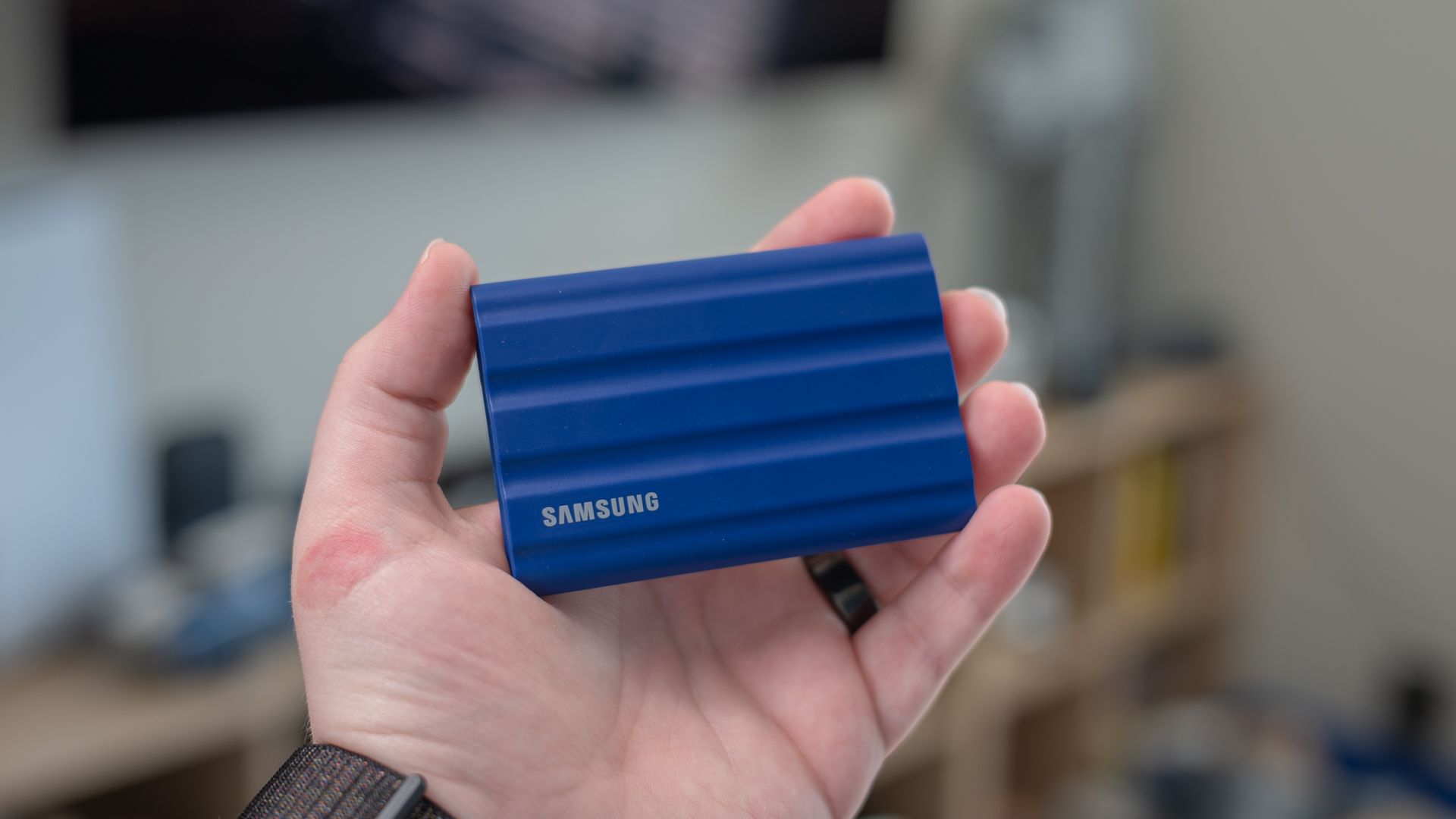 Samsung T7 Shield portable SSD held in a person's hand