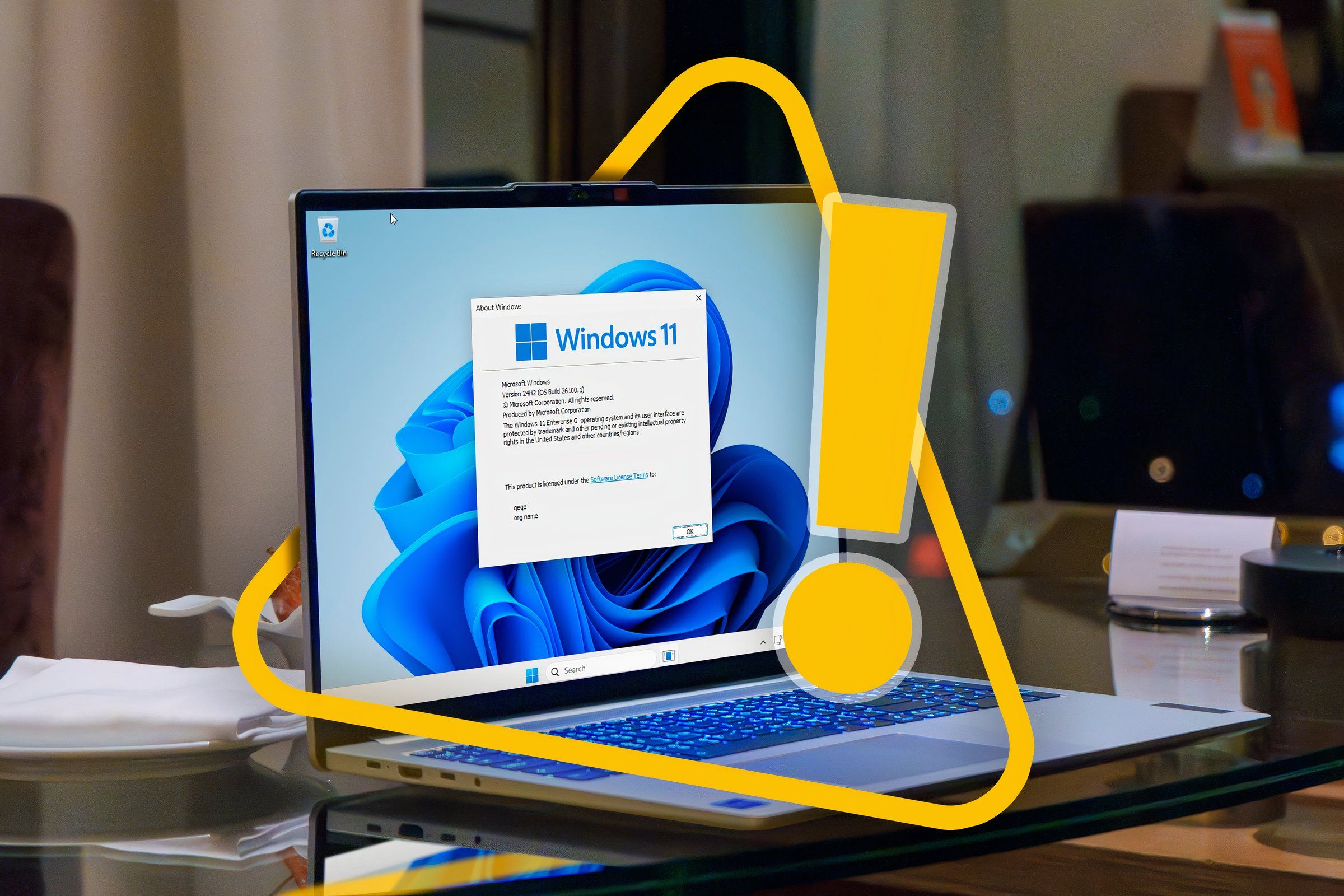 A laptop with Windows 11 and an alert sign.