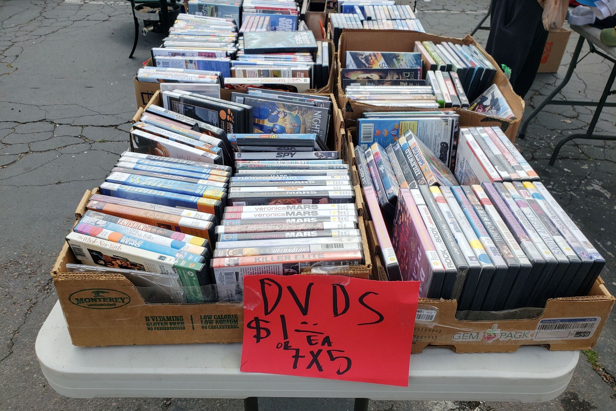 A view of several boxes filled with used DVDs.