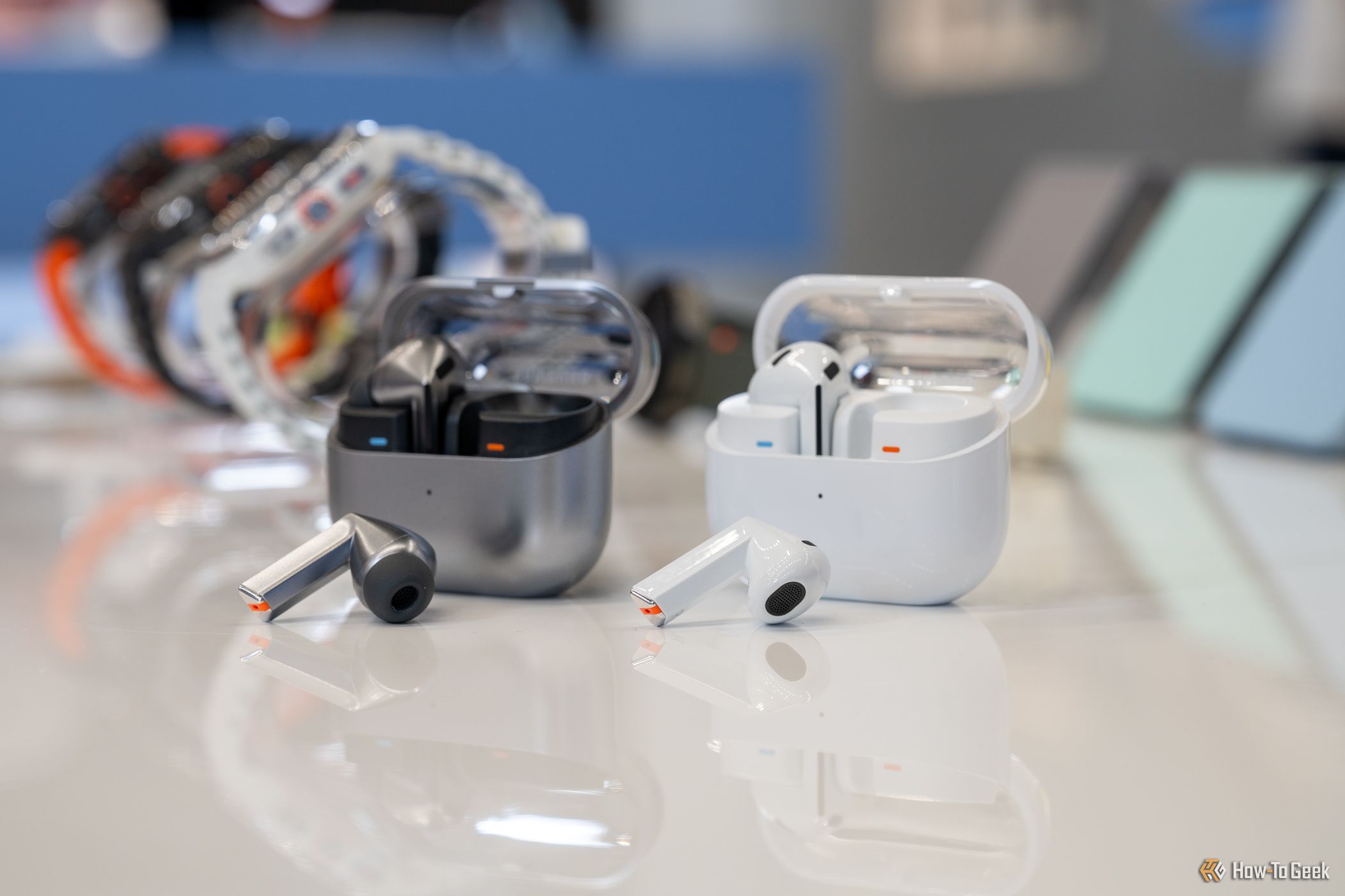 Samsung Galaxy Buds 3 Pro and Samsung Galaxy Buds 3 sitting on a table outside their charging cases