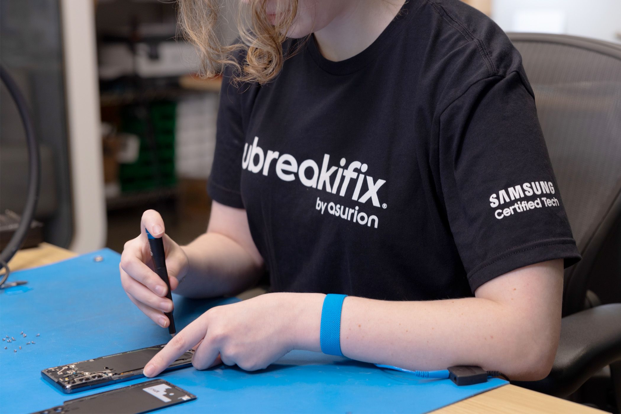 Person at a uBreakiFix store fixing a phone.