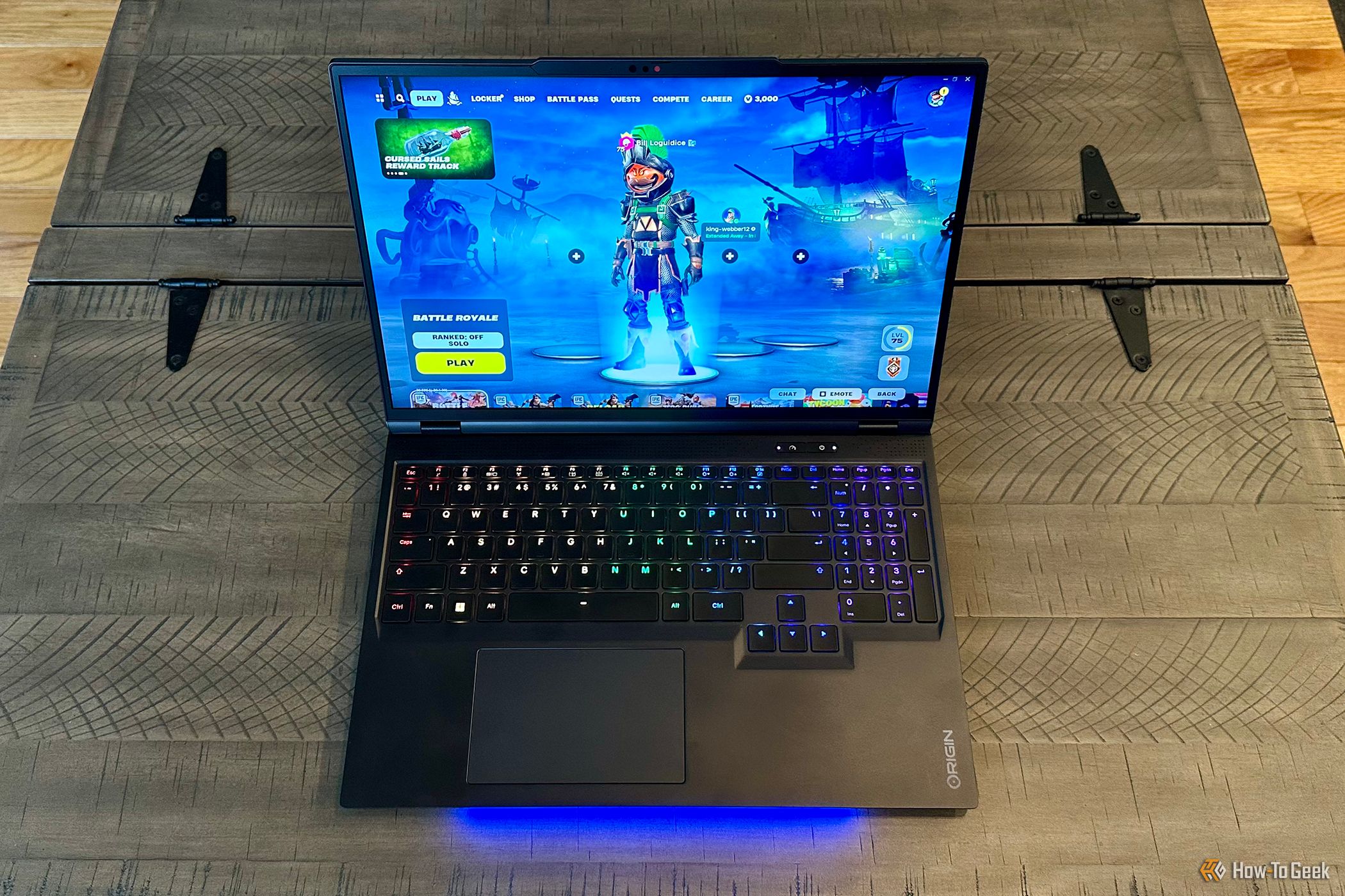 Origin PC EON16-X Laptop open a table top running Fortnite