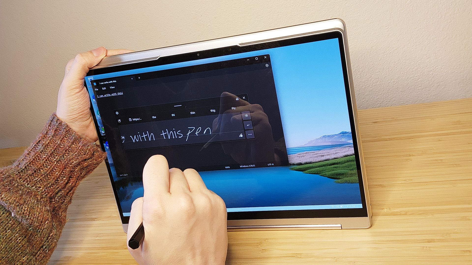 Person writing on the Lenovo Yoga 9i Gen 8 laptop screen with the included stylus