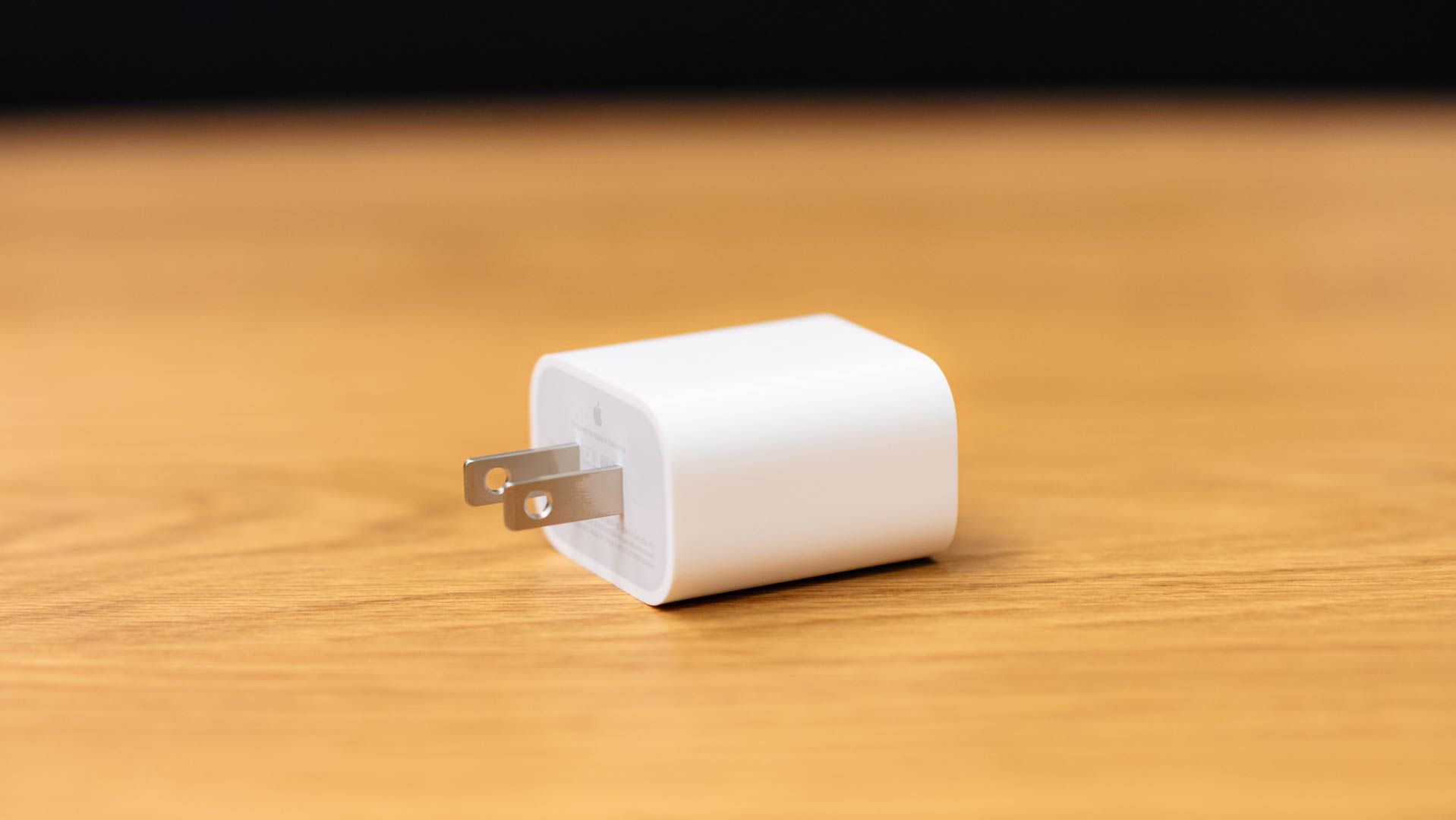 Apple power adapter brick on a wood table