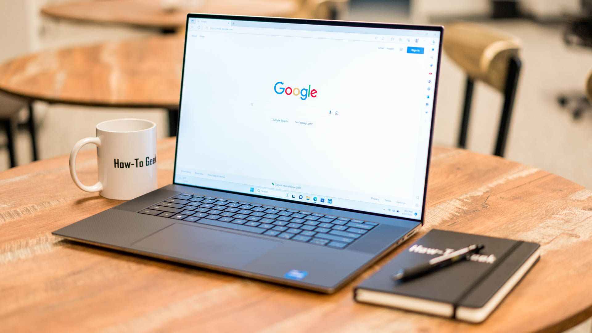 Dell XPS 17 set up on a table with a notebook.