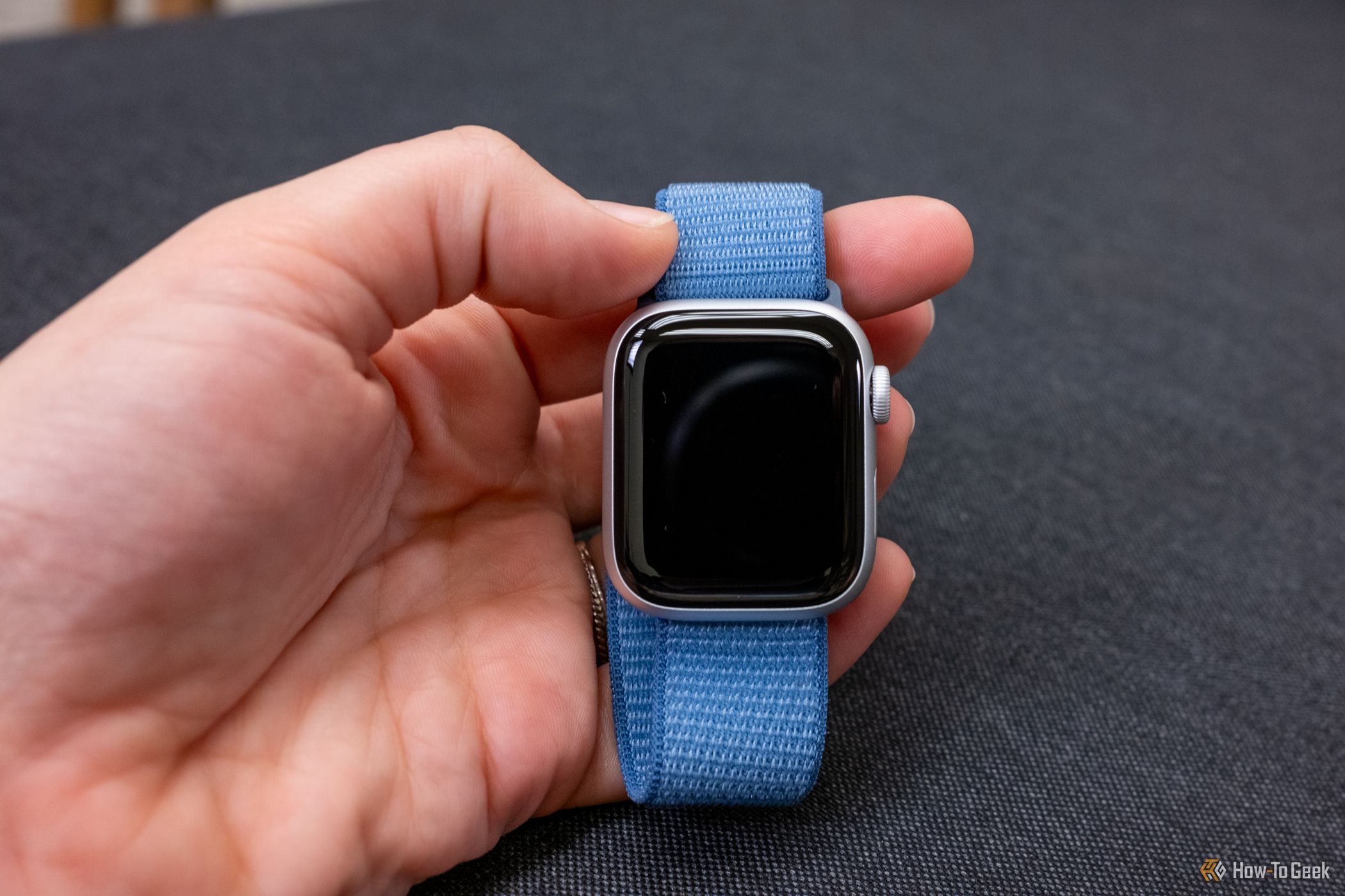 Someone holding a 41mm Apple Watch, face is black.