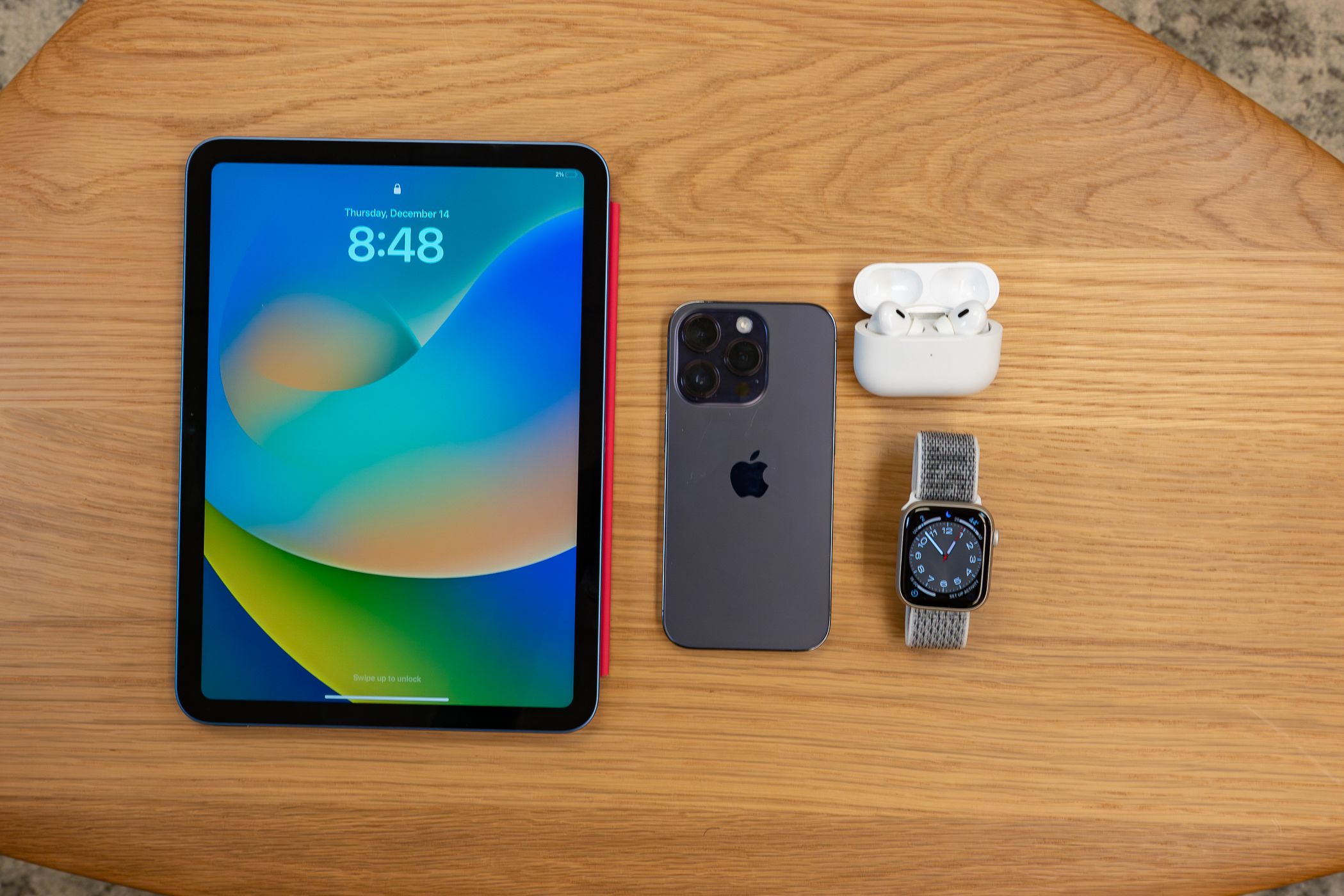 Top view of the iPAd Pro, iPhone 14, Apple watch and Airpods