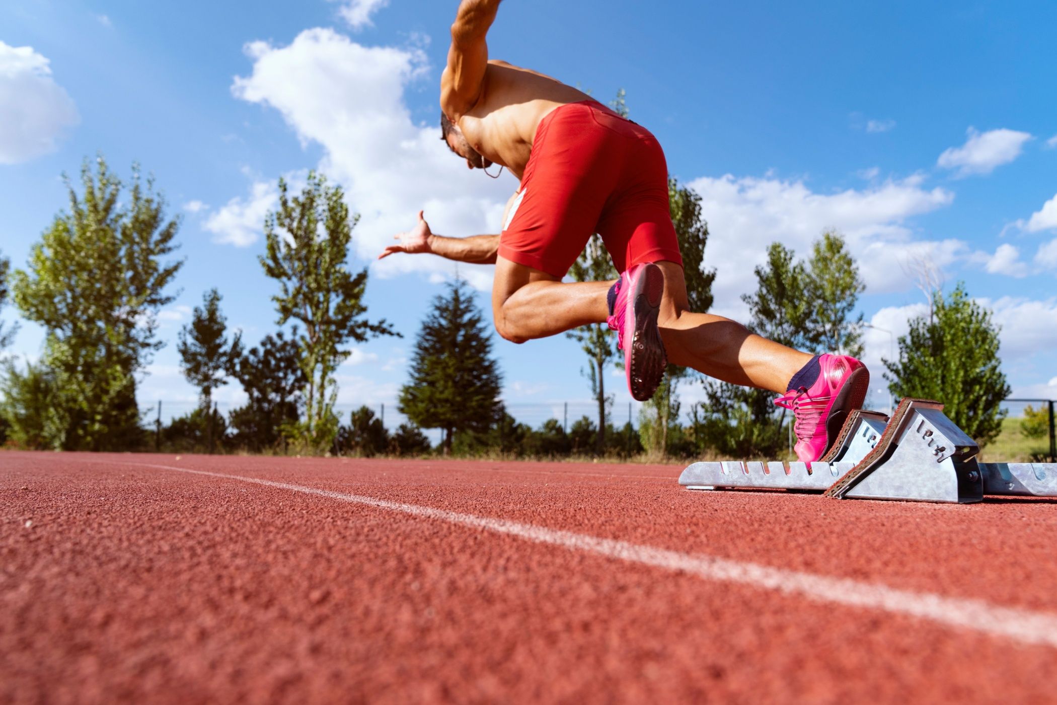 An athlete launching himself off the starting block.