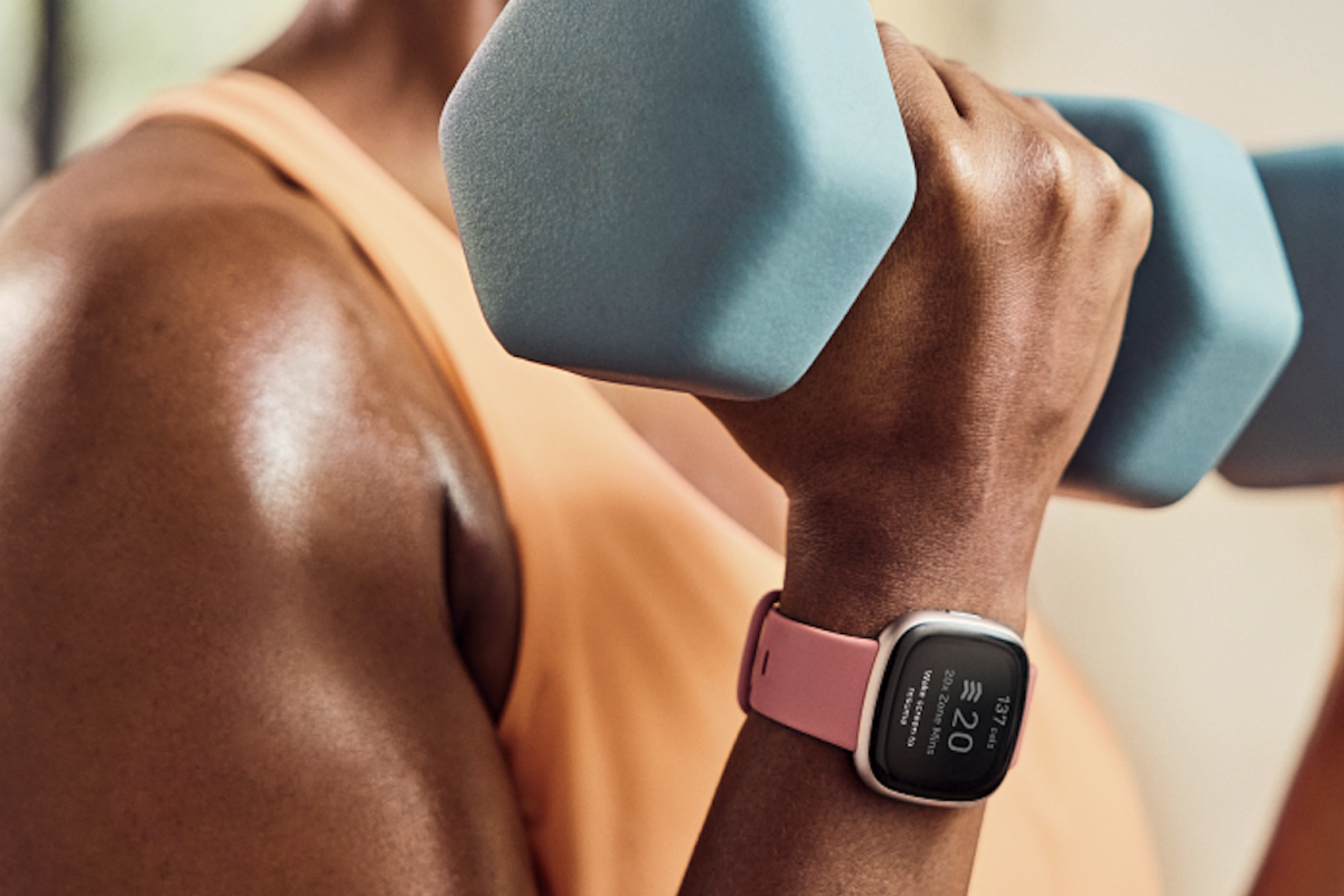 A Fitbit Versa 4 being used in the gym.