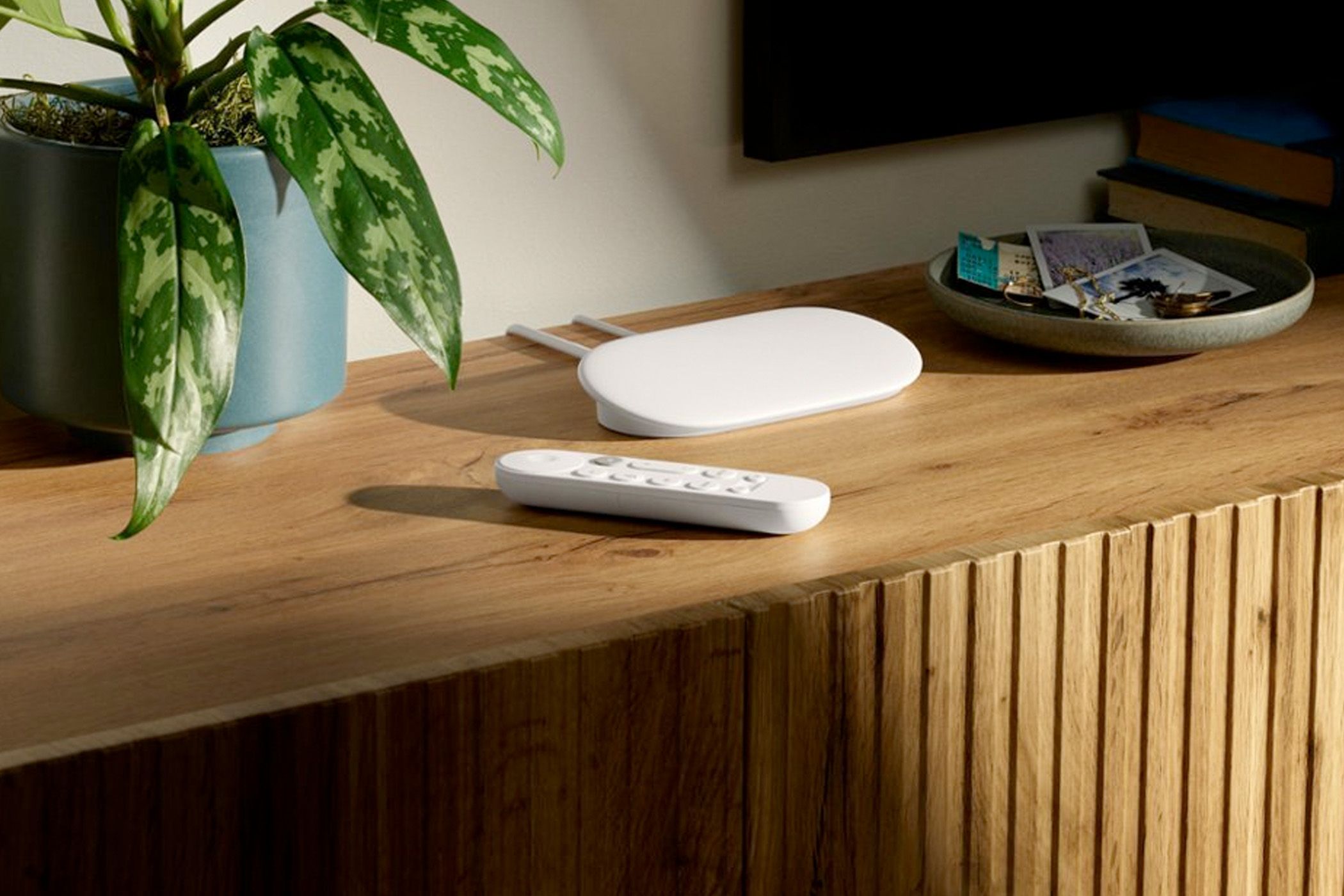 Google TV Streamer box on top of a TV cabinet.