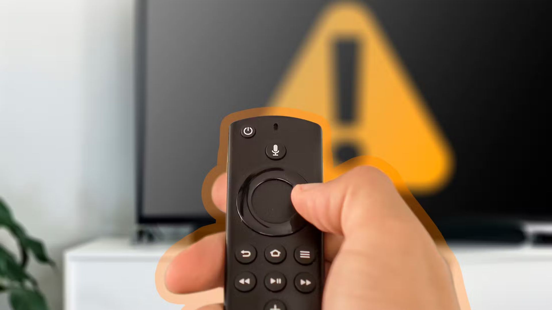 hand holding a fire TV remote with a TV in the background.