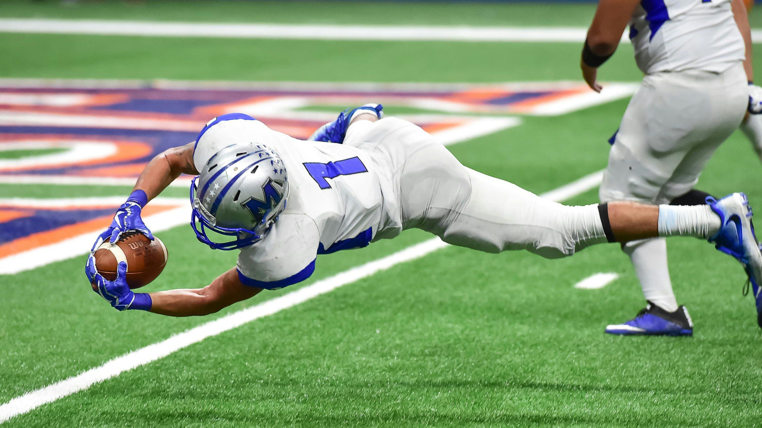 a football player diving into the end zone and scoring a touchdown