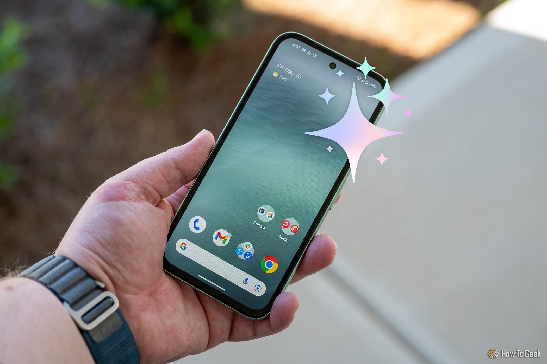 Person holding the Google Pixel 8a showing the home screen and bezels