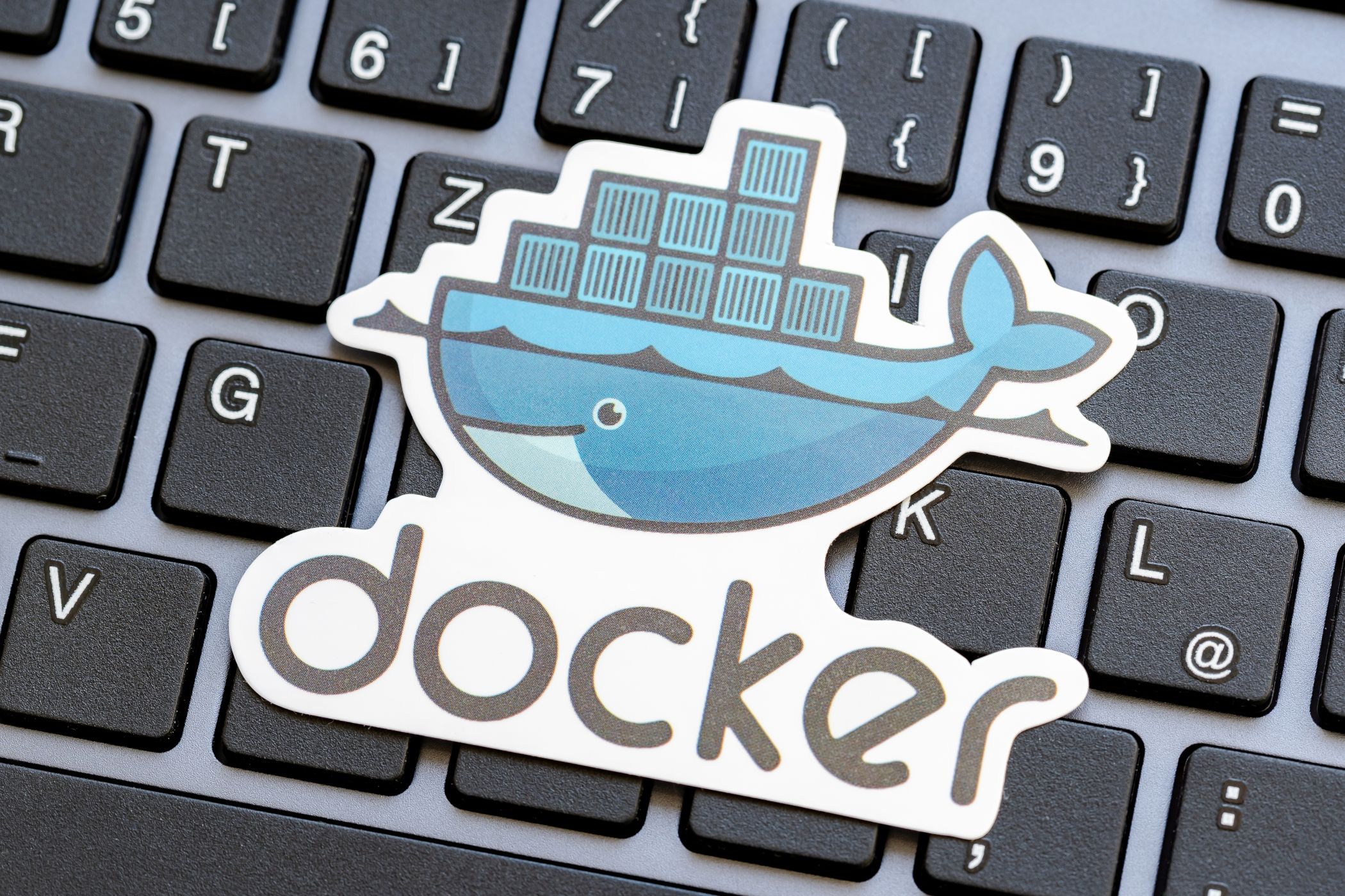 Docker logo placed over a laptop computer keyboard.