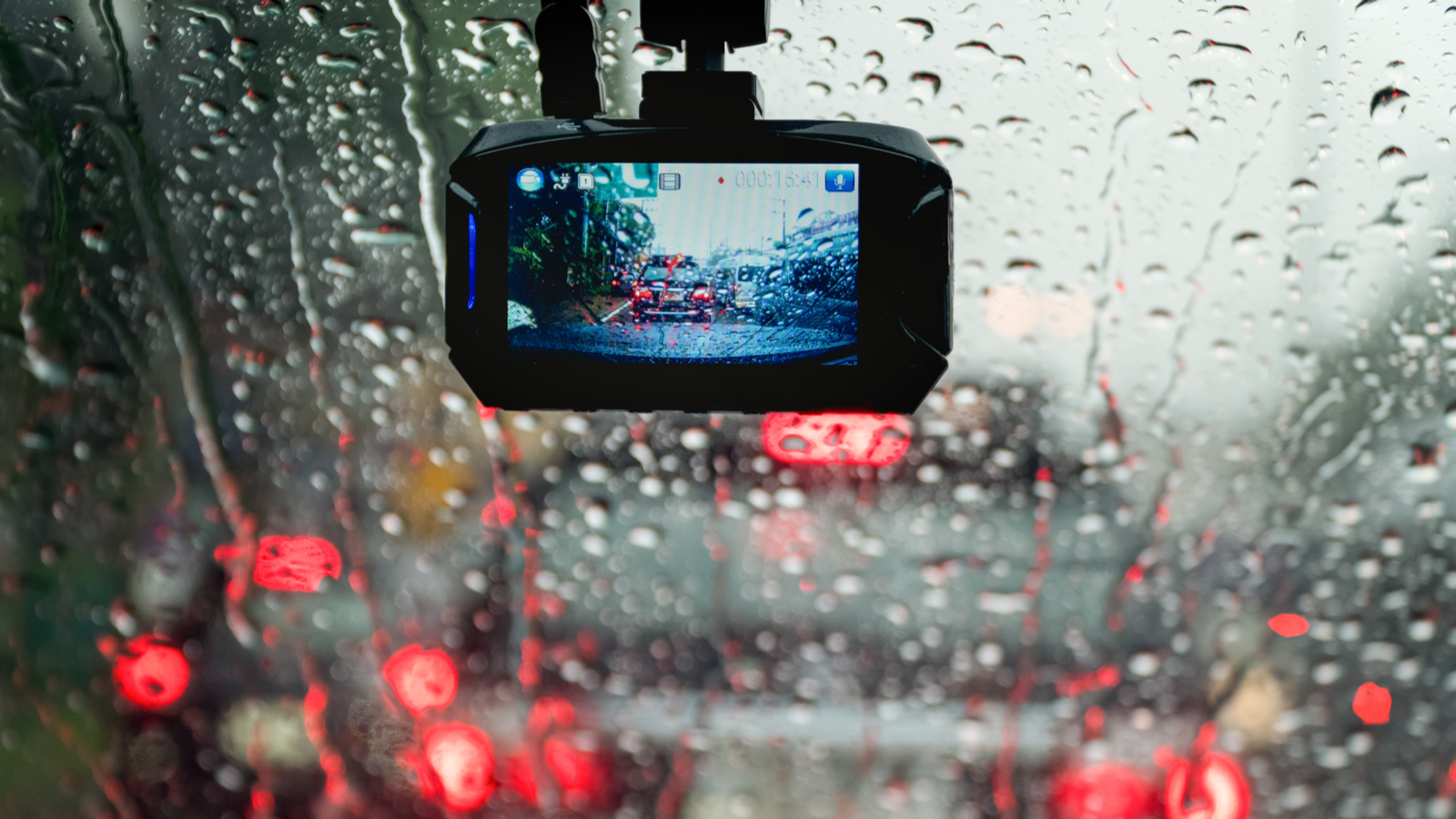 Car dash cam running mounted to a rainy windshield