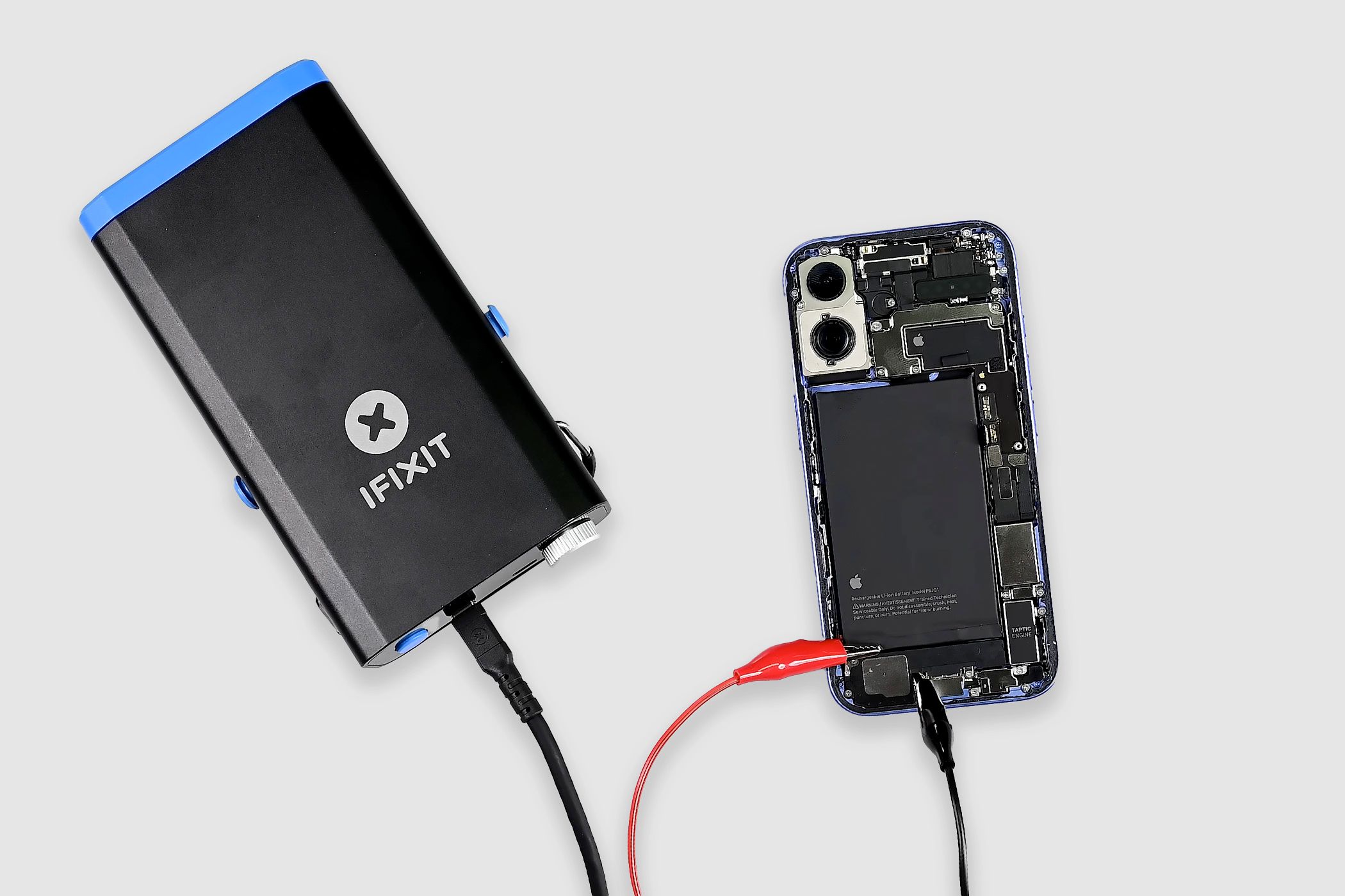 The iPhone 16's battery hooked up to an iFixit soldering workstation.