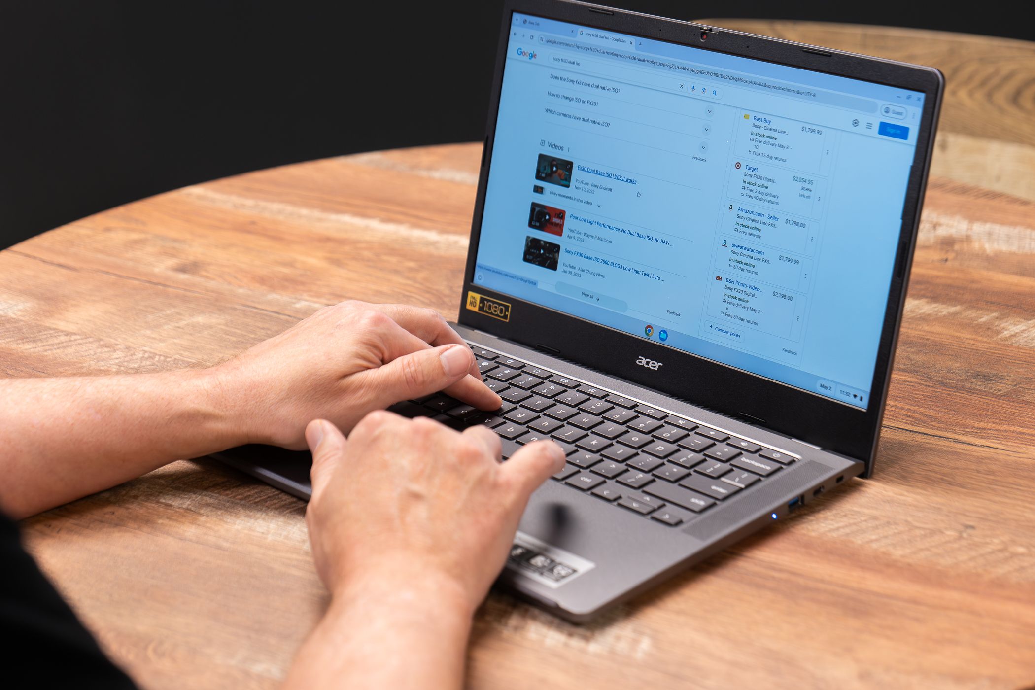 A person using an Acer Chromebook on a table.