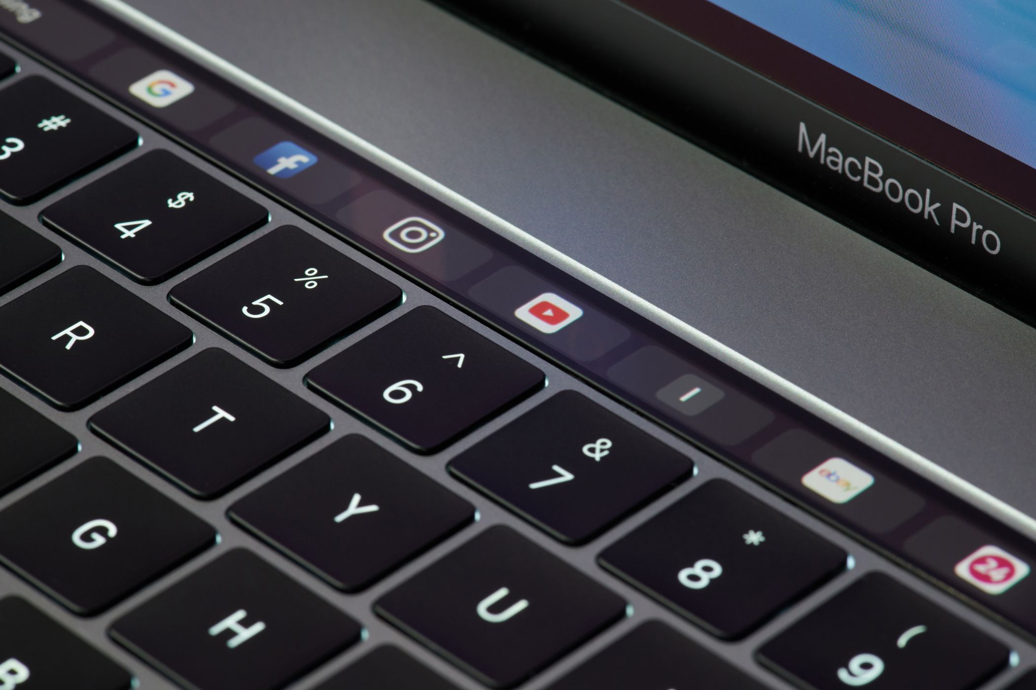 A MacBook Pro with Safari icons on the Touch Bar.