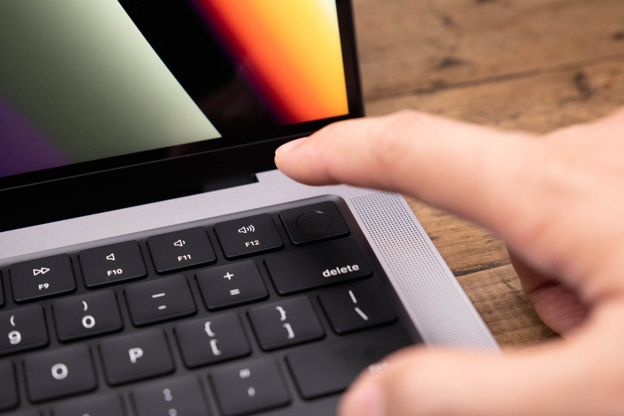 A person authenticating on a MacBook using Touch ID.