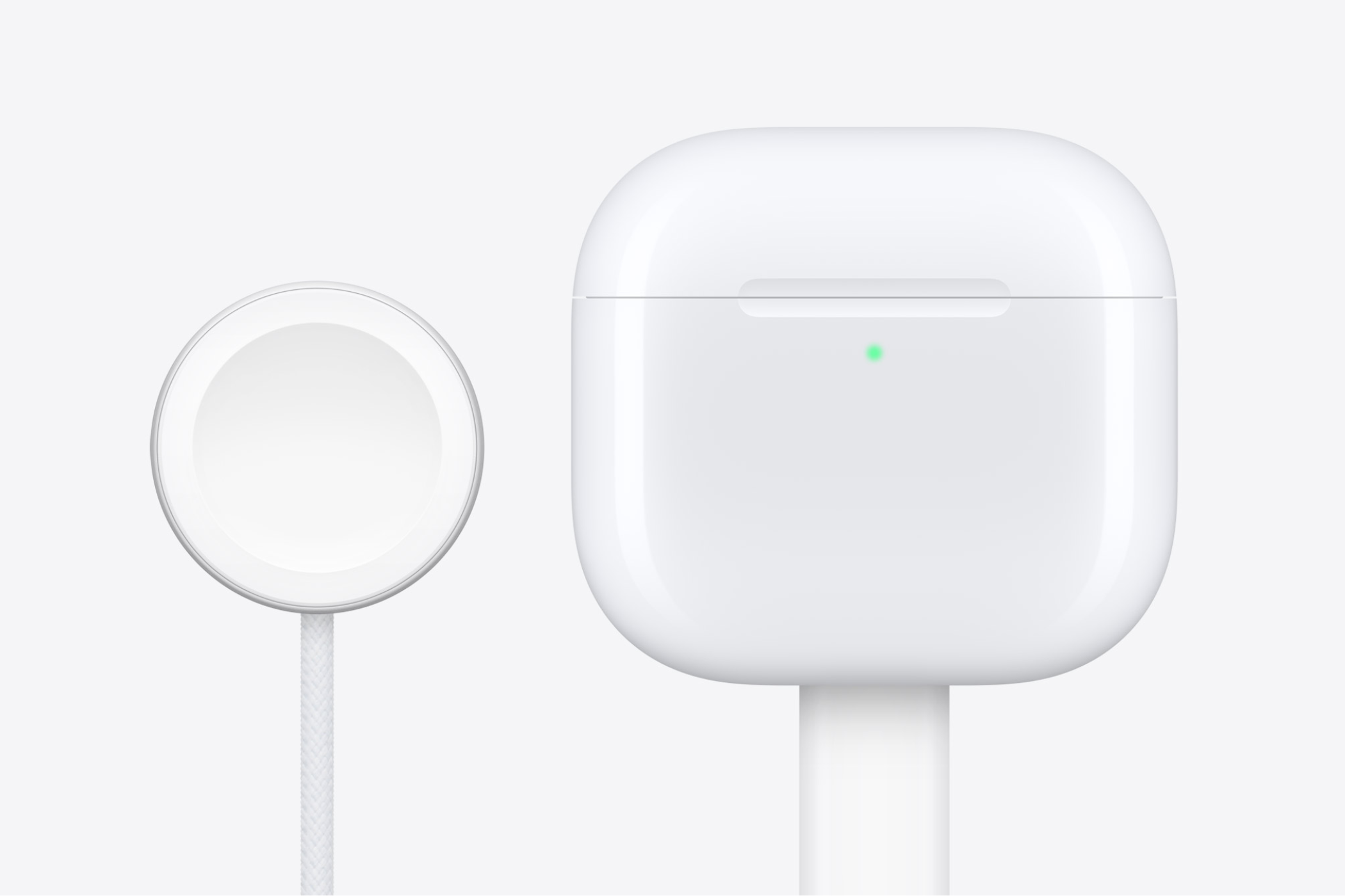 AirPods 4 with a USB-C cable attached to them and an Apple Watch charging puck next to them.