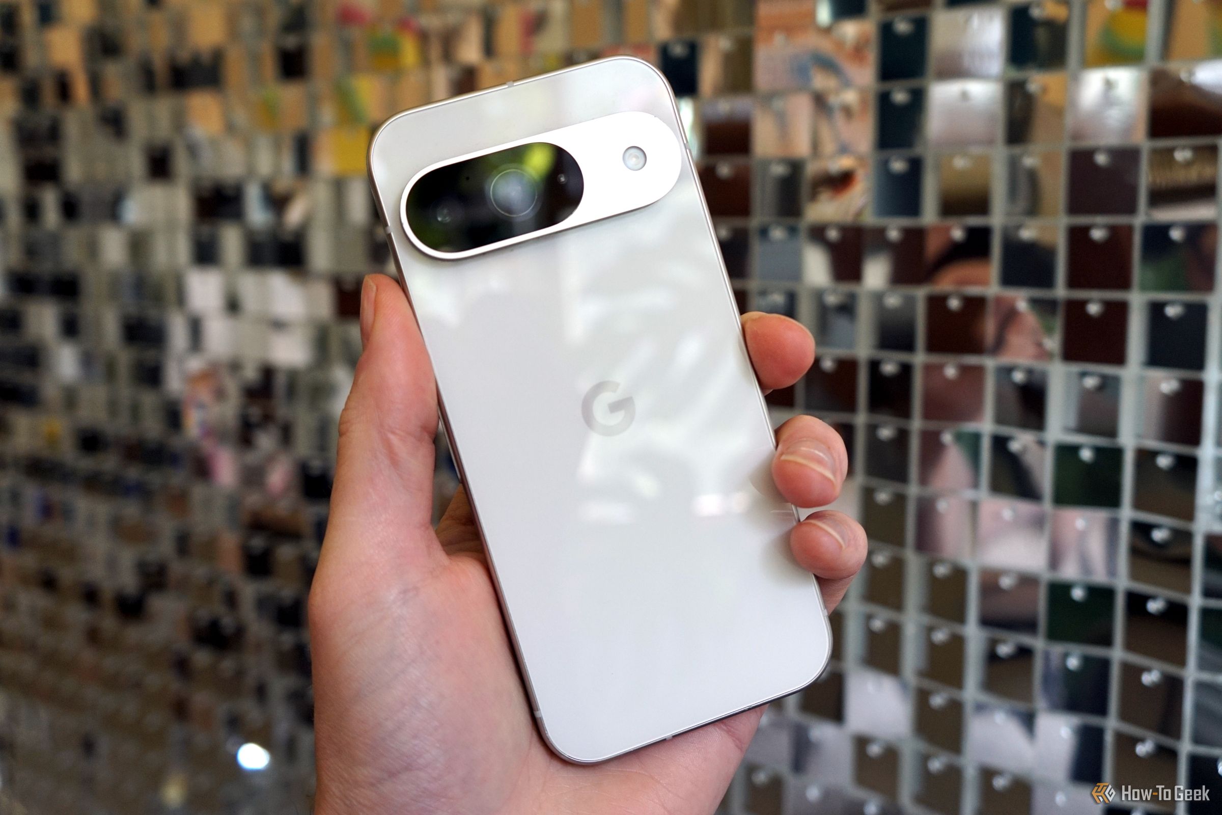 Google Pixel 9 in front of a disco ball wall.