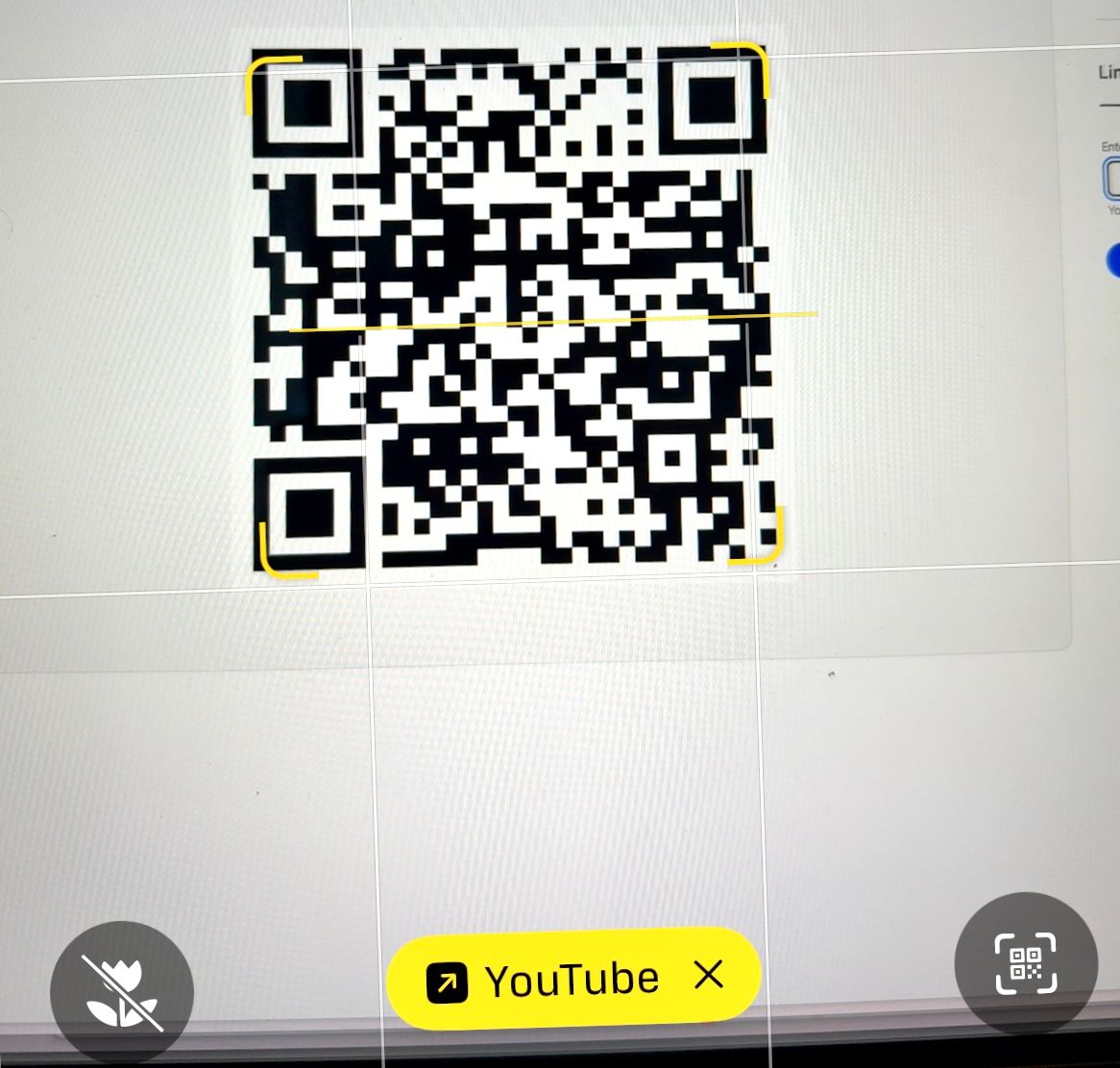 A photograph of a QR code in the iPhone Camera app, with the link showing in yellow at the bottom of the screen.