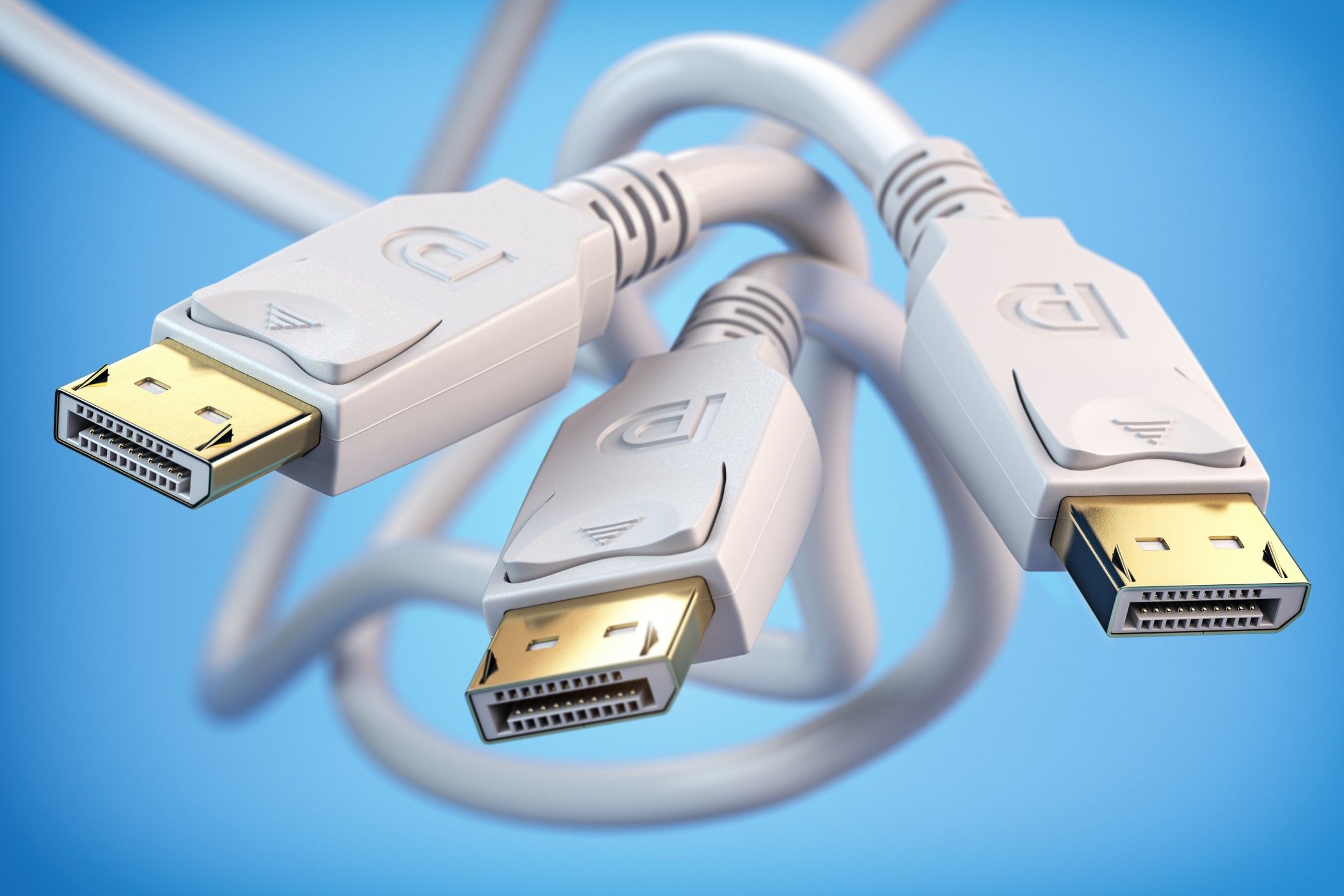 Three white DisplayPort cables tangled together over a blue backdrop.