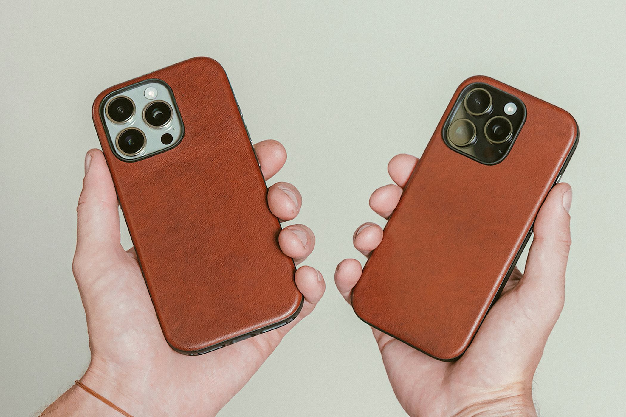 Hands holding the iPhone 16 Pro with a Nomad Olde Dublin leather case.