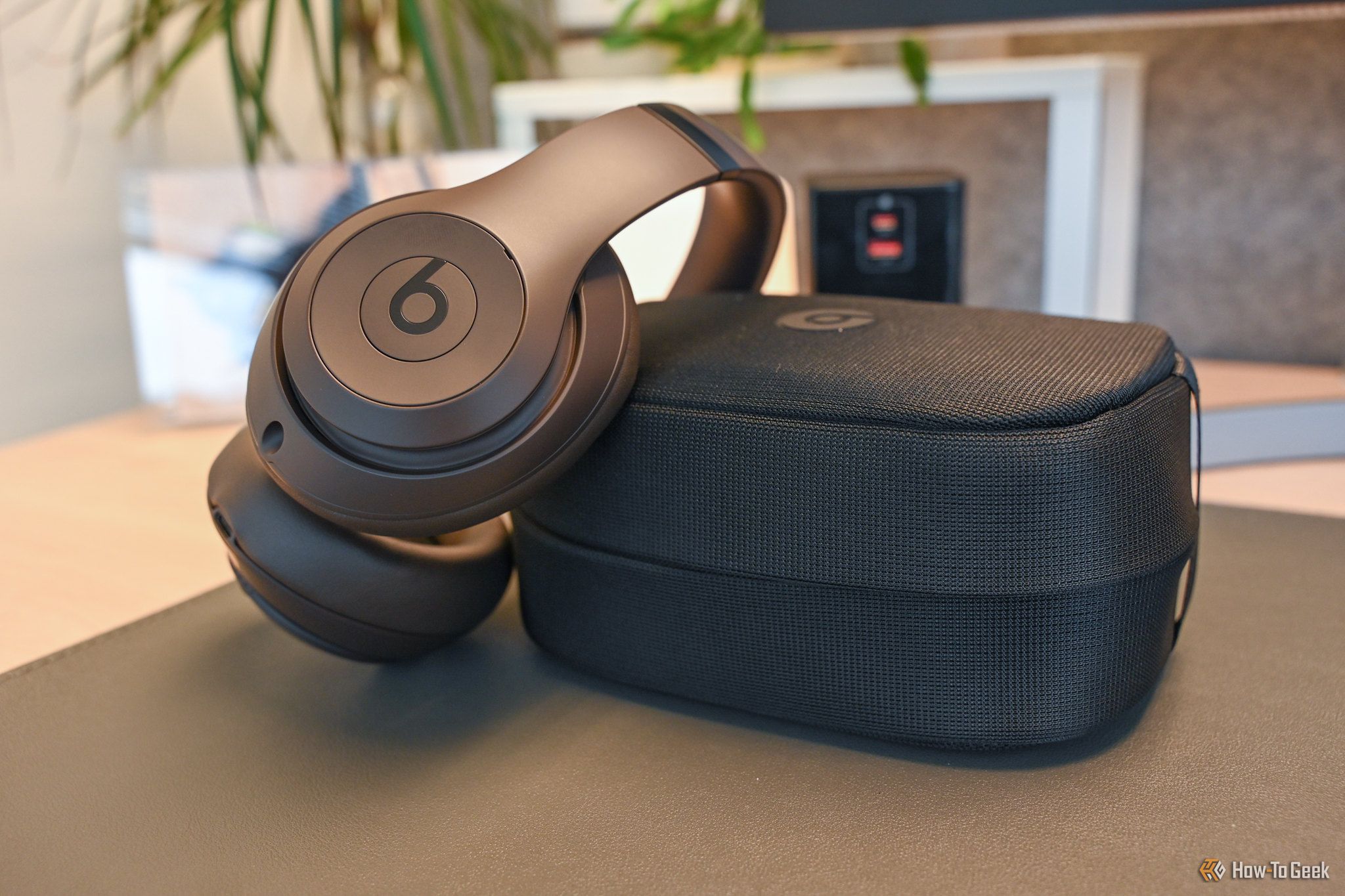 Beats Studio Pro in deep brown leaning on their included carrying case