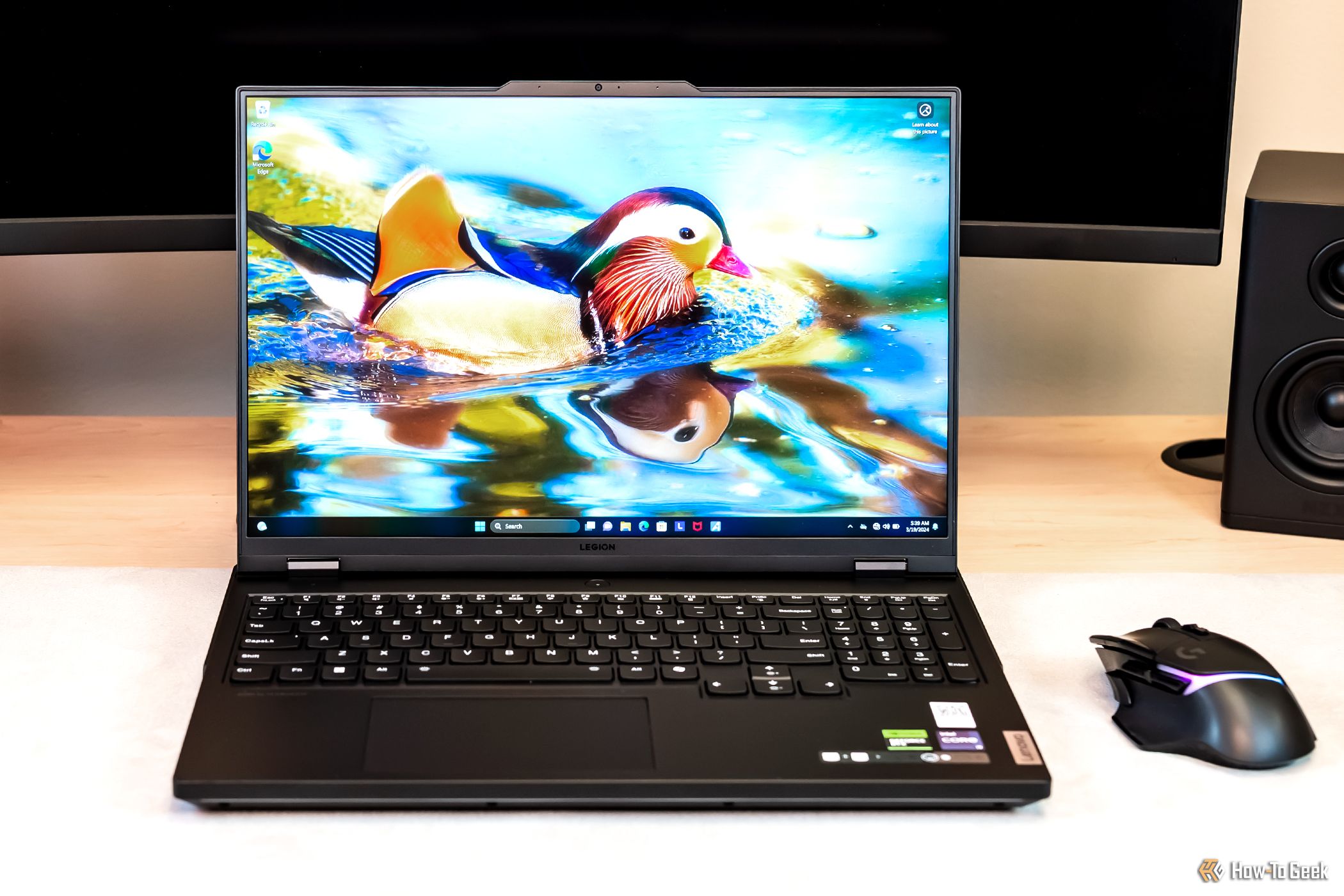 A laptop with elegant display placed close to a mouse on the table.