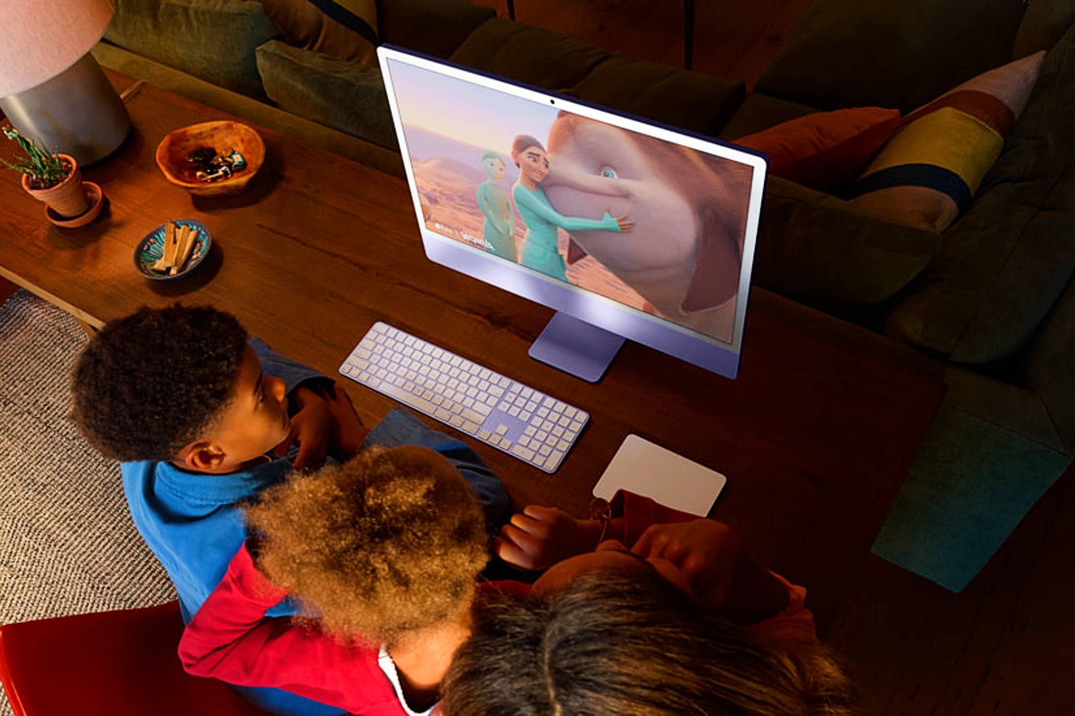 Apple iMac M4 24 inch Retina display with children near and using accessories with an animated movie playing on screen