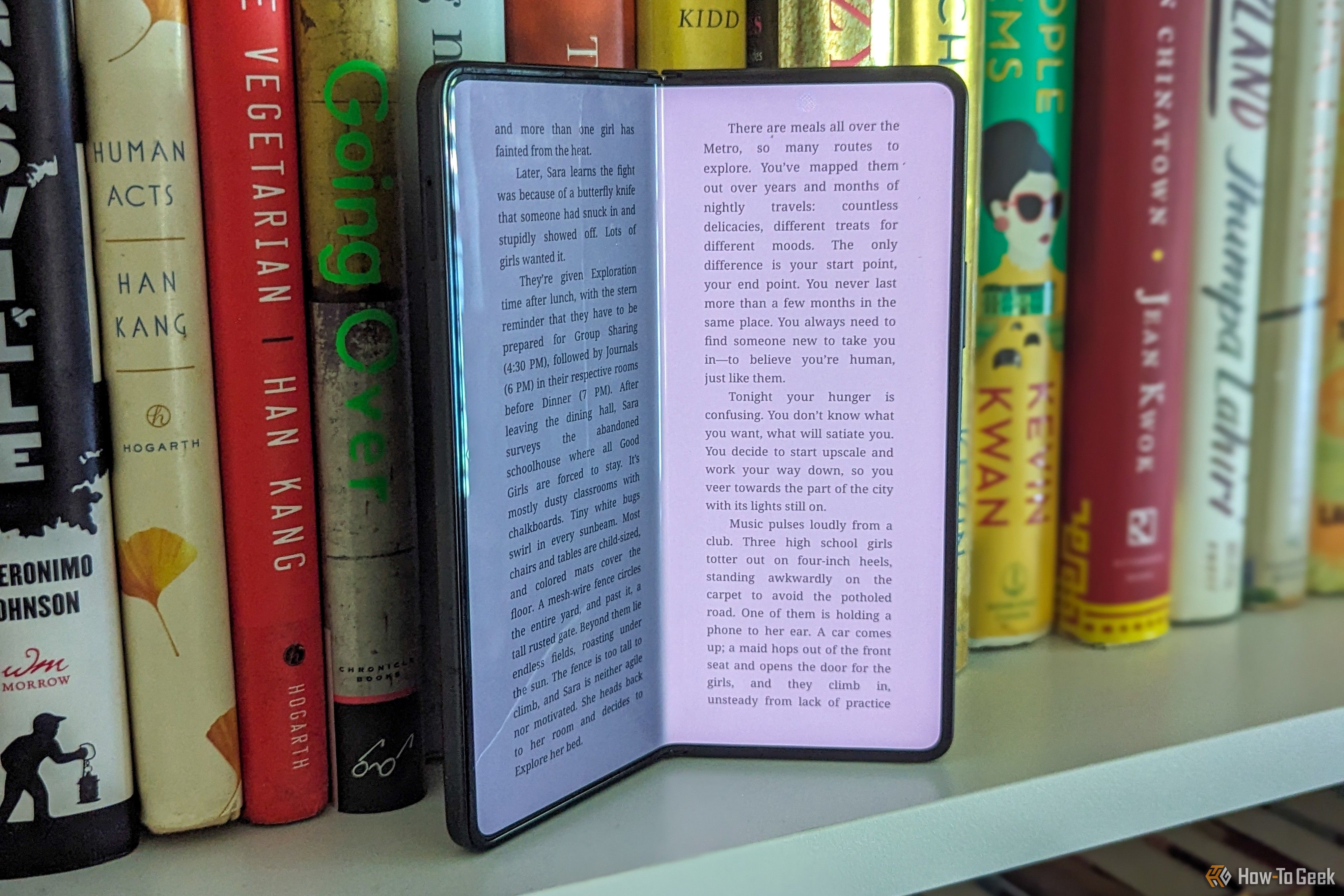 A slightly open Samsung Galaxy Z Fold 5 on a bookshelf.