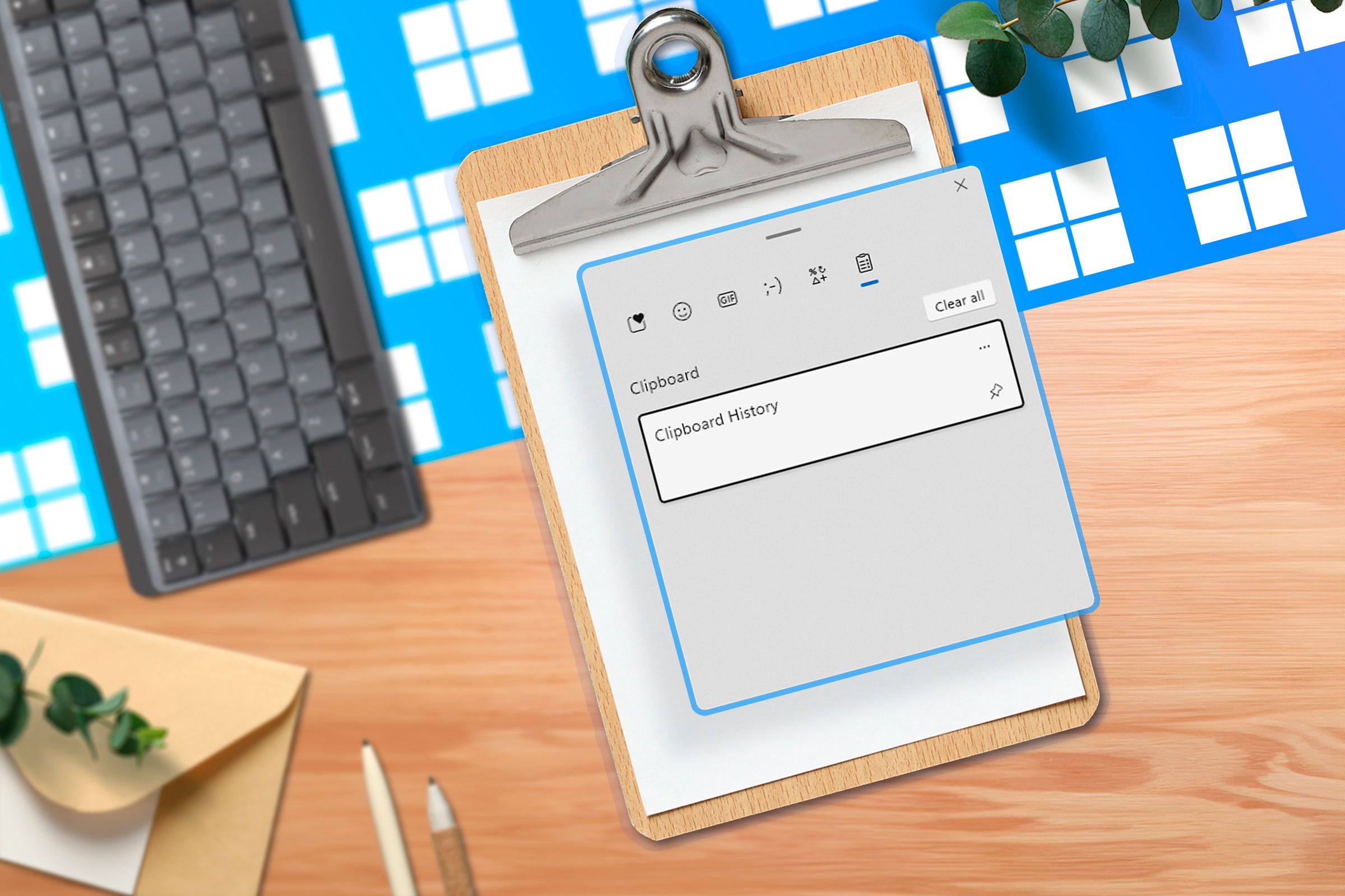 A clipboard with a screenshot of the clipboard history on a wooden desk, a keyboard next to it, and several Windows logos in the background.