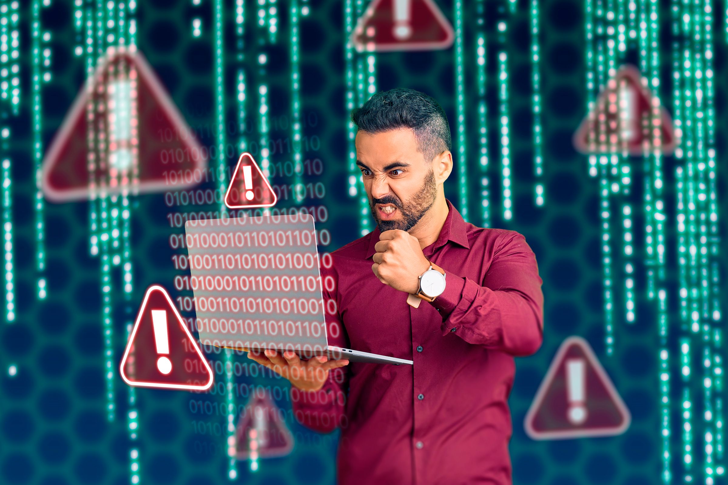 A man angrily holding a laptop with codes around him and warning signs.