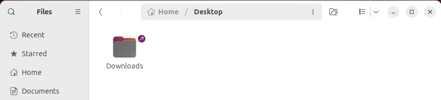 An Ubuntu file manager window showing a symbolic link to the Downloads folder in the desktop folder.