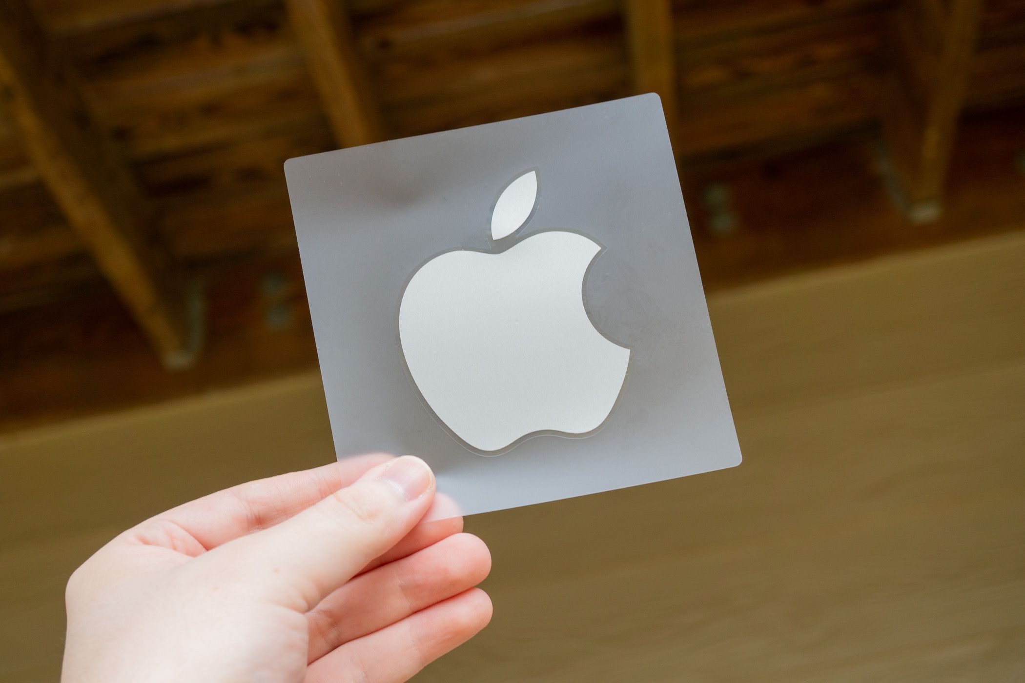 A person holding an Apple sticker.