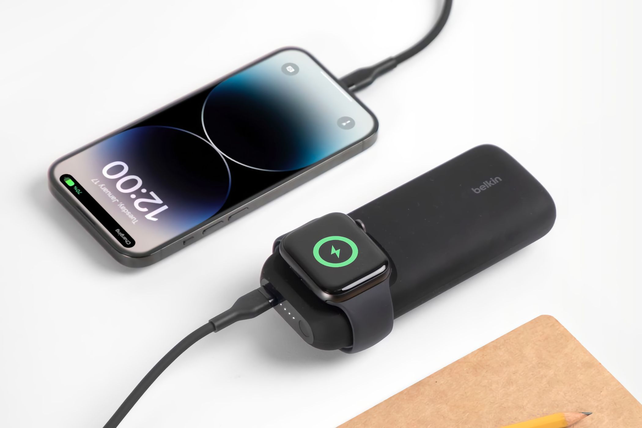 Belkin power bank wirelessly charging an Apple Watch and an iPhone via a cable.