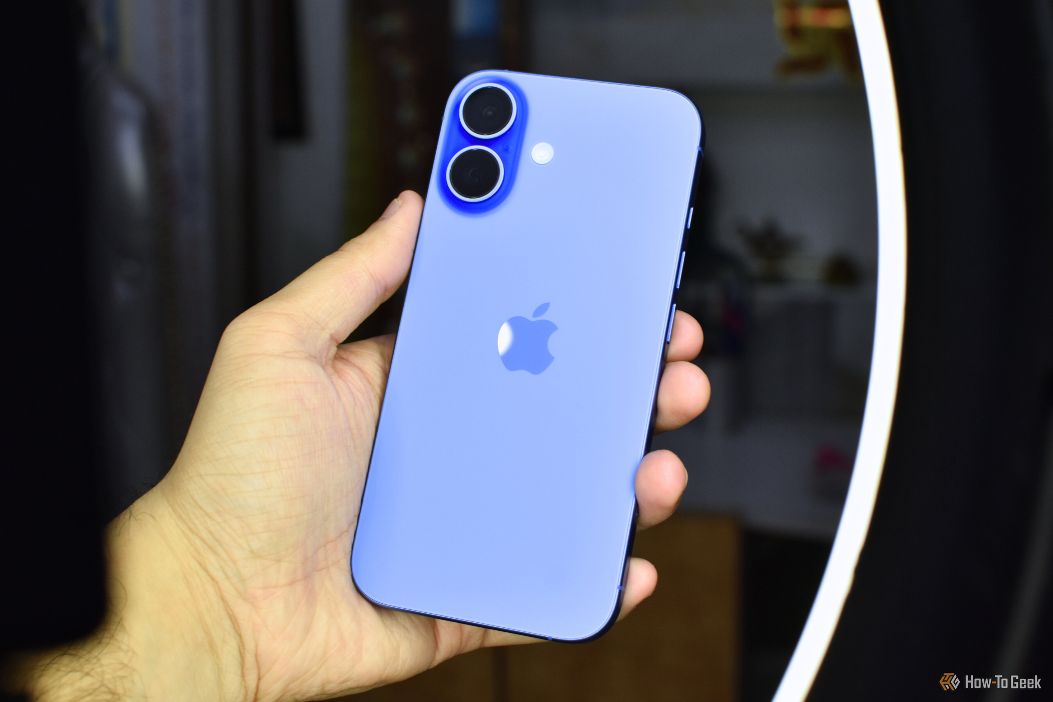 iPhone 16 in Ultramarine color in a hand.