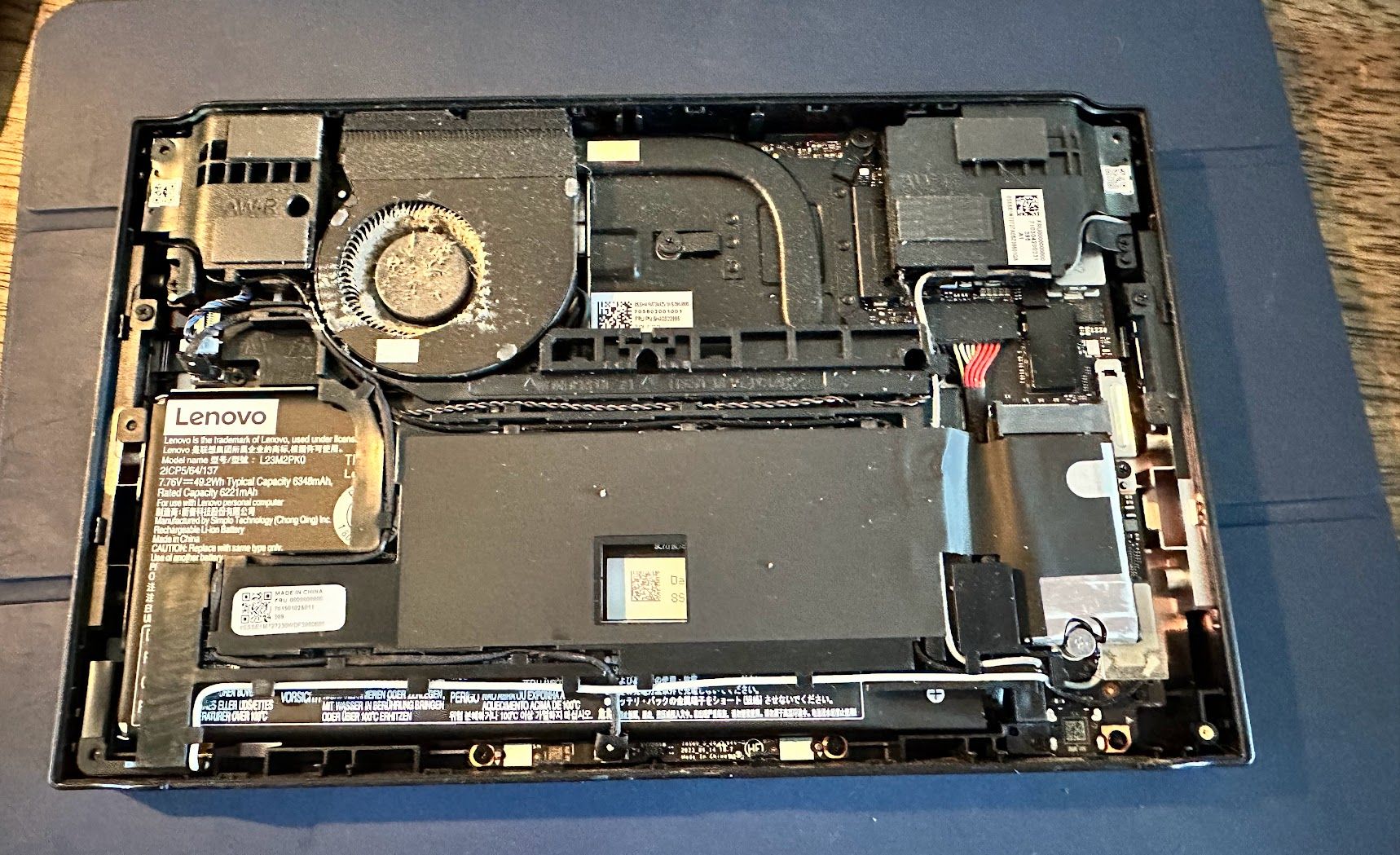 Lenovo Legion Go with back plate removed, showing heavy dust inside the cooling fan.