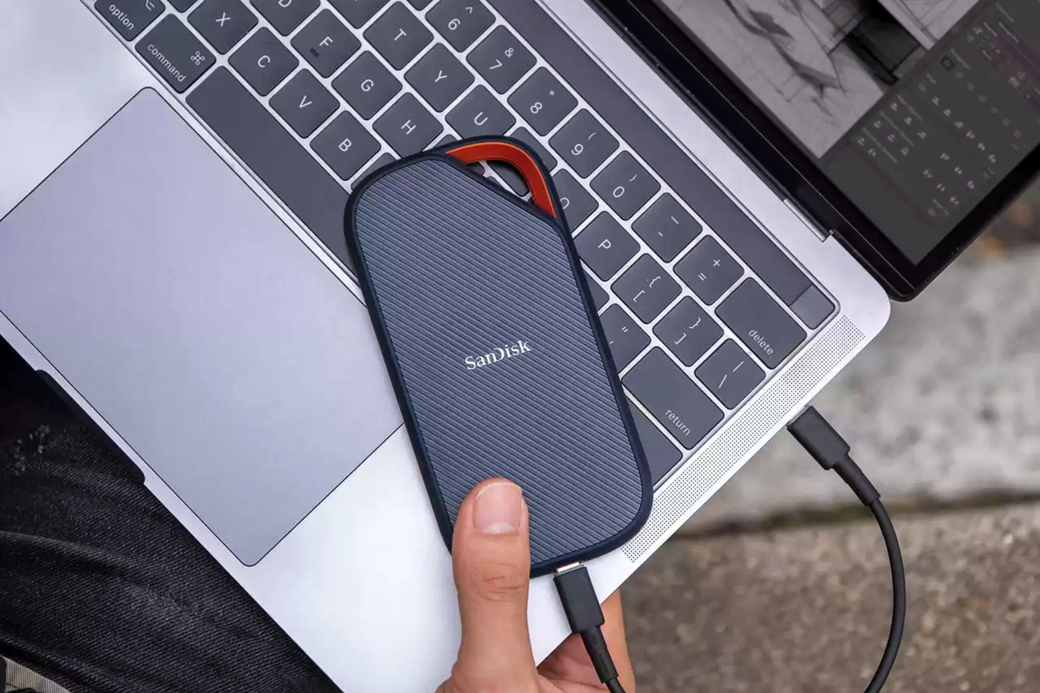 sandisk extreme pro usb 4 portable ssd on a laptop near a thumb