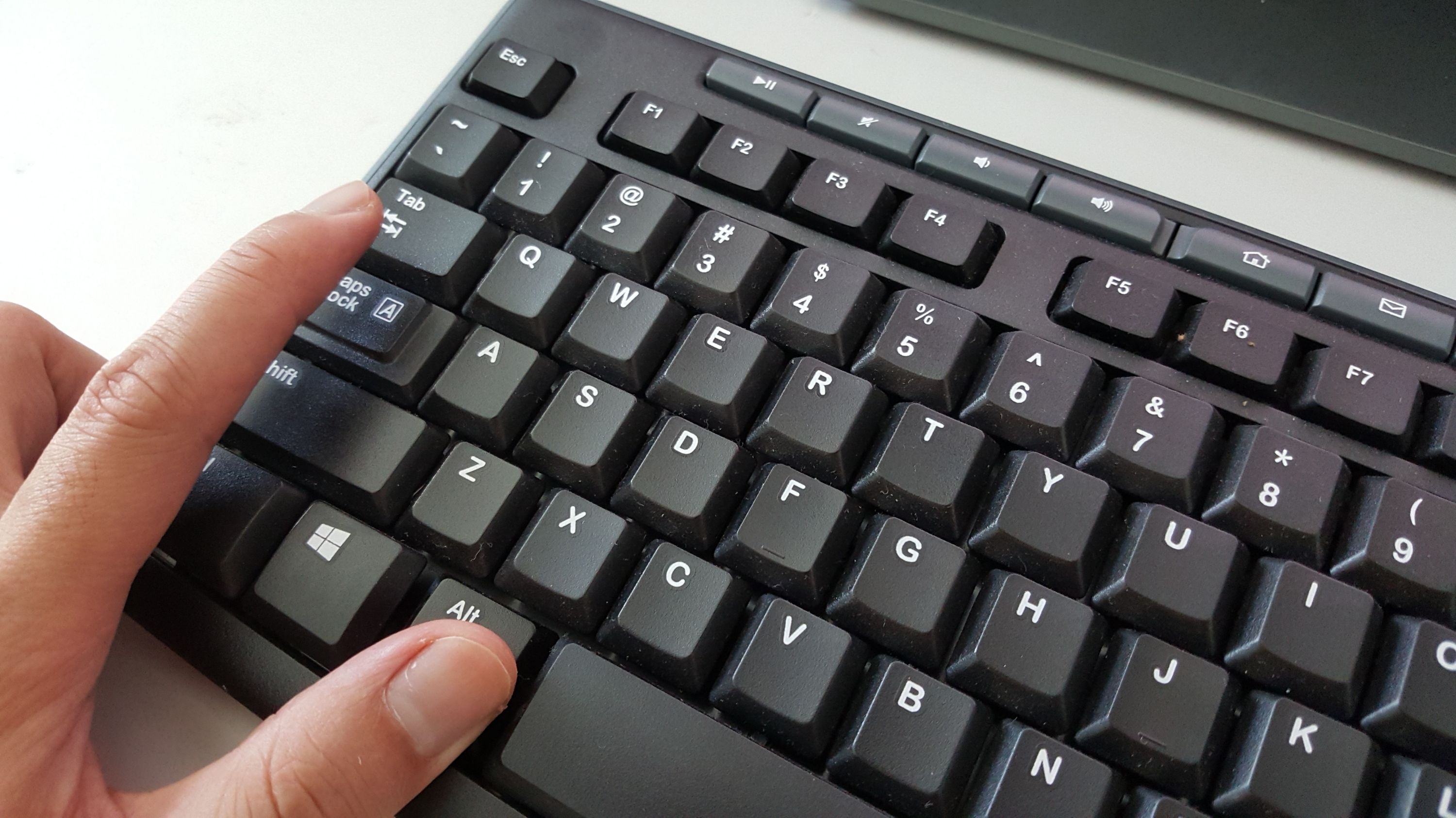 Finger pressing alt-tab command on the keyboard.