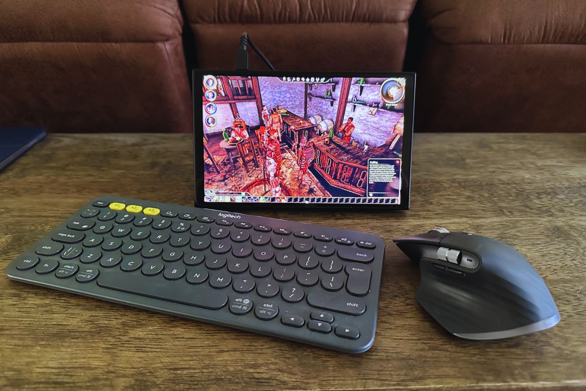 A Logitech K380 keyboard, MX Master 3S mouse, and Lenovo Legion Go on a wooden desk.