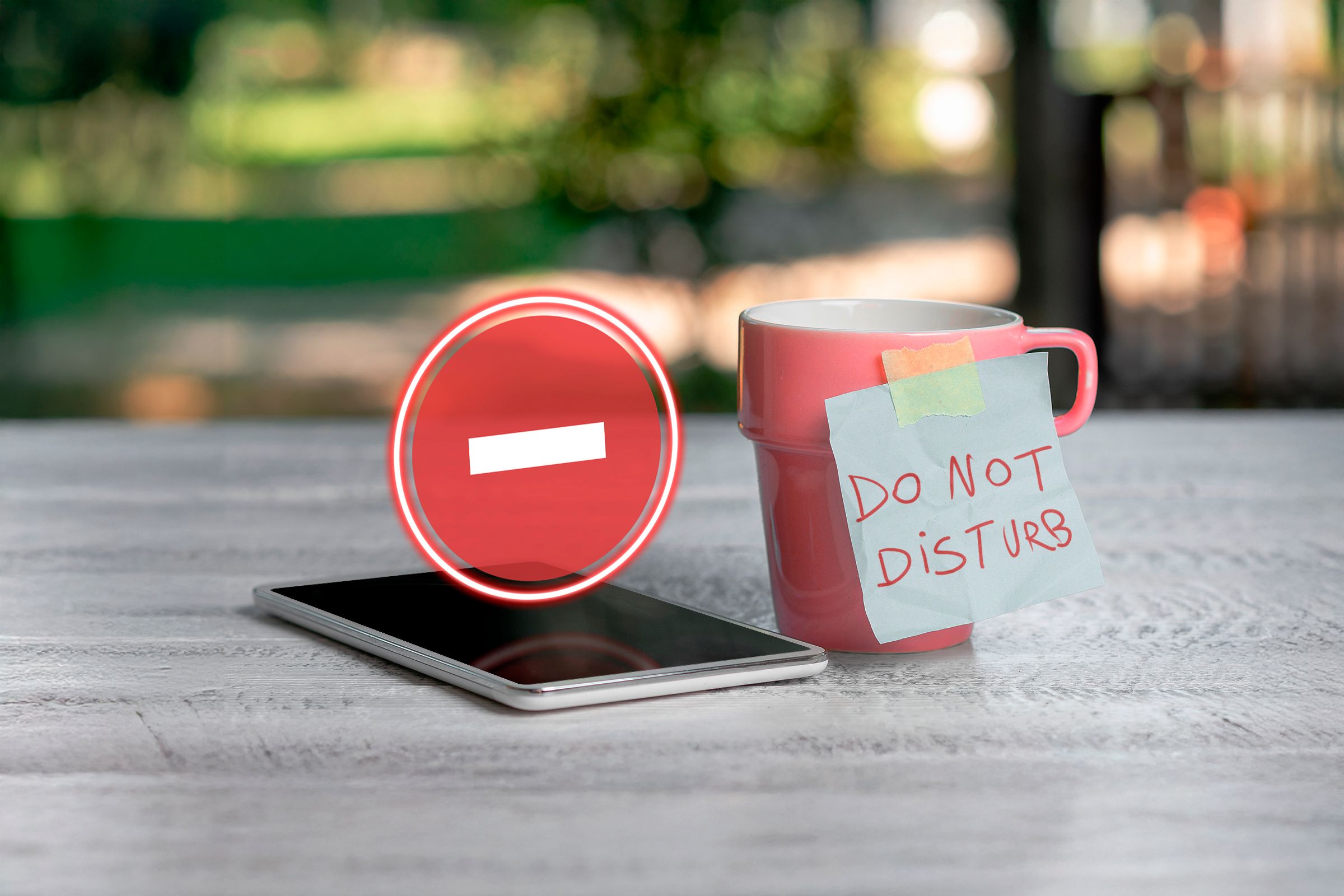 A phone with the Do Not Disturb icon hovering above the screen and a mug next to it labeled 'Do Not Disturb'.