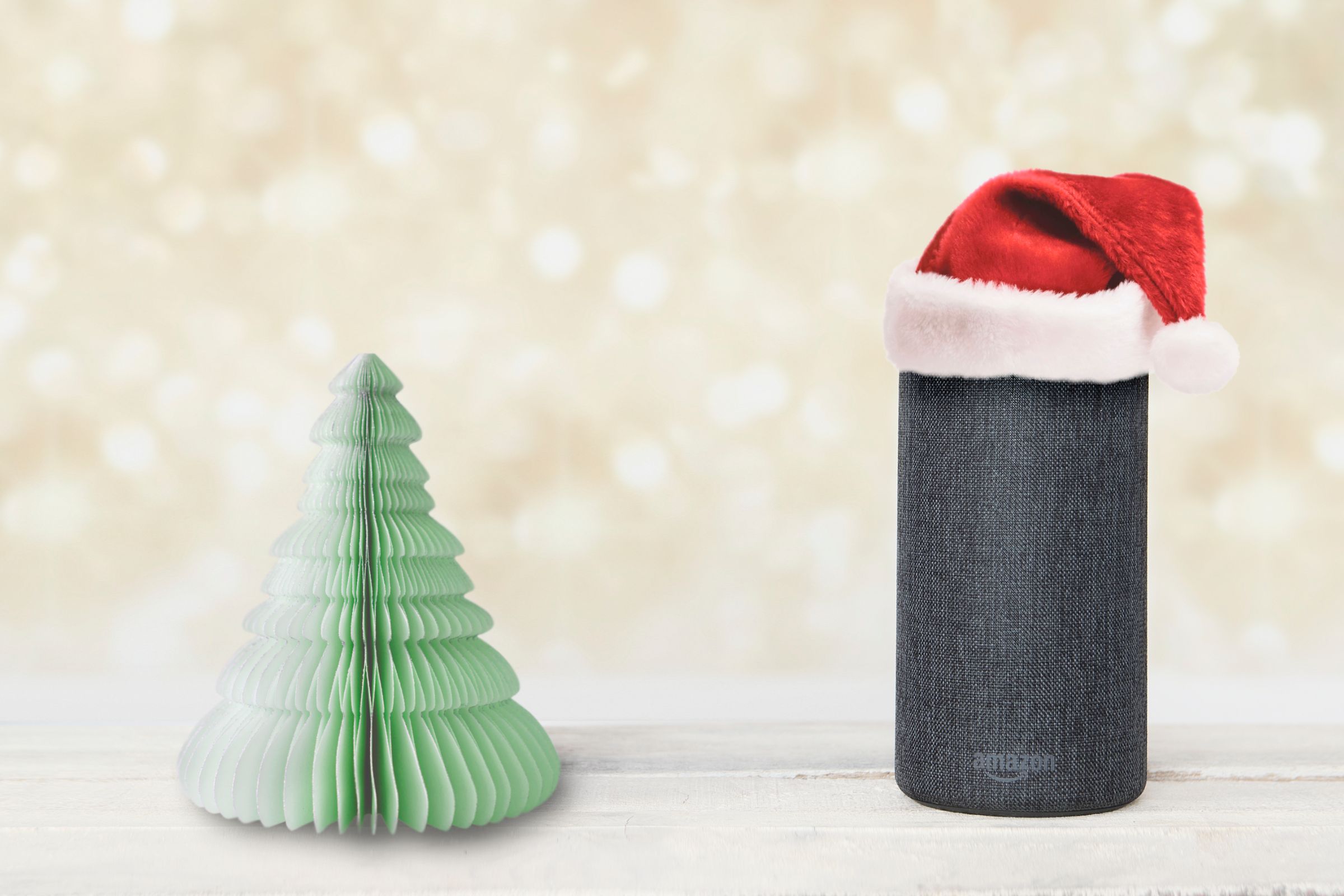 Amazon Alexa with a santa hat and Christmas tree.